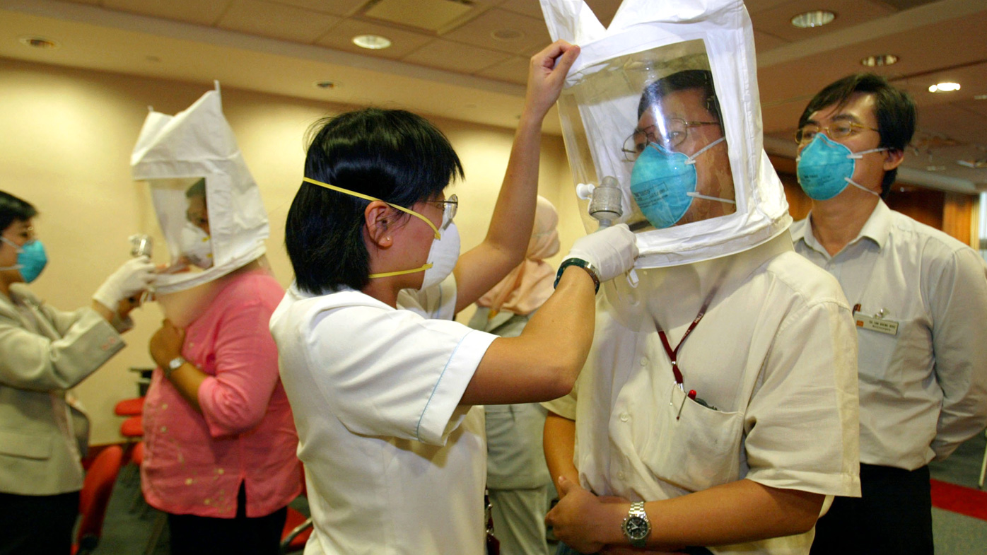 In this 2003 photo, employees at the Tan Tock Seng hospital are fitted for masks that offer protection against the Severe Acute Respiratory Syndrome (SARS) virus in Singapore.