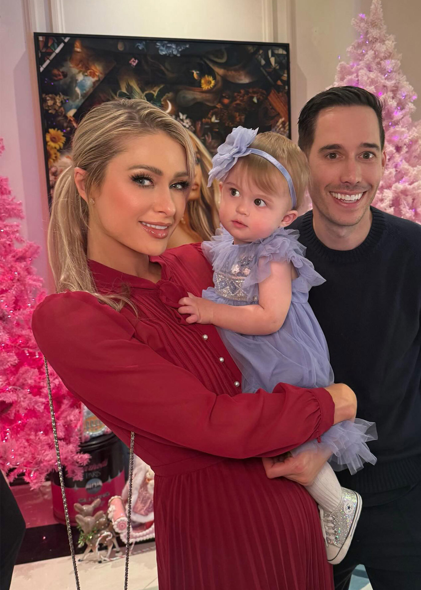 Paris Hilton with her daughter London and Husband Carter Reum in front of their pink Christmas trees in 2024