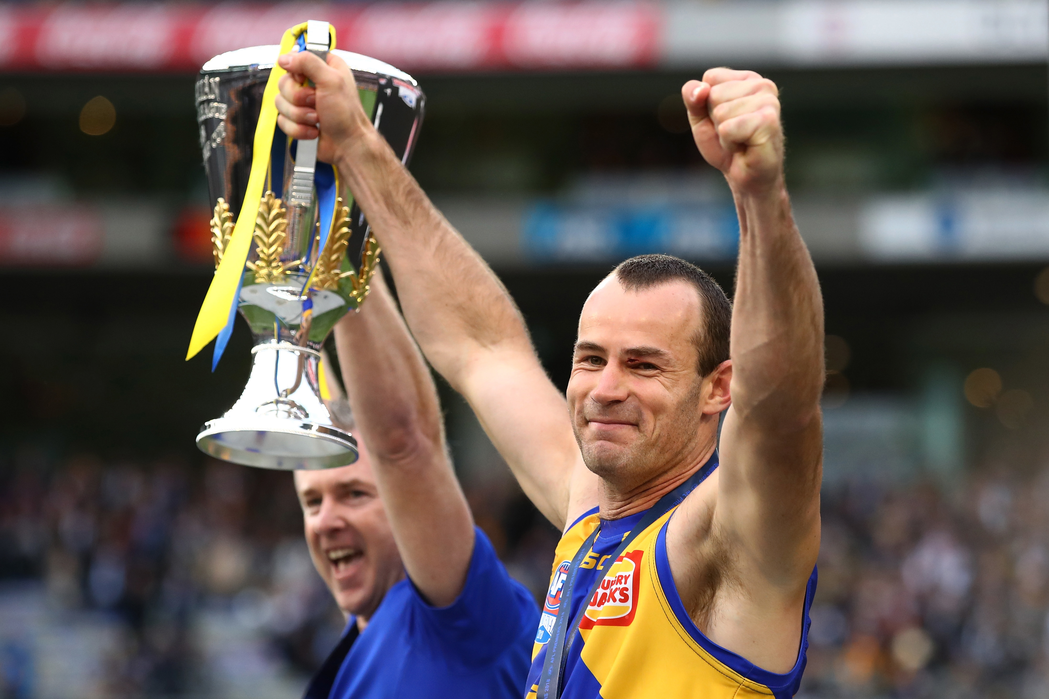 MELBOURNE, AUSTRALIA - SEPTEMBER 29: Adam Simpson, Senior Coach of the Eagles and Eagles captain Shannon Hurn hold the AFL Premiership Cup aloft after winning the 2018 Toyota AFL Grand Final match between the West Coast Eagles and the Collingwood Magpies at the Melbourne Cricket Ground on September 29, 2018 in Melbourne, Australia. (Photo by Cameron Spencer/AFL Media)