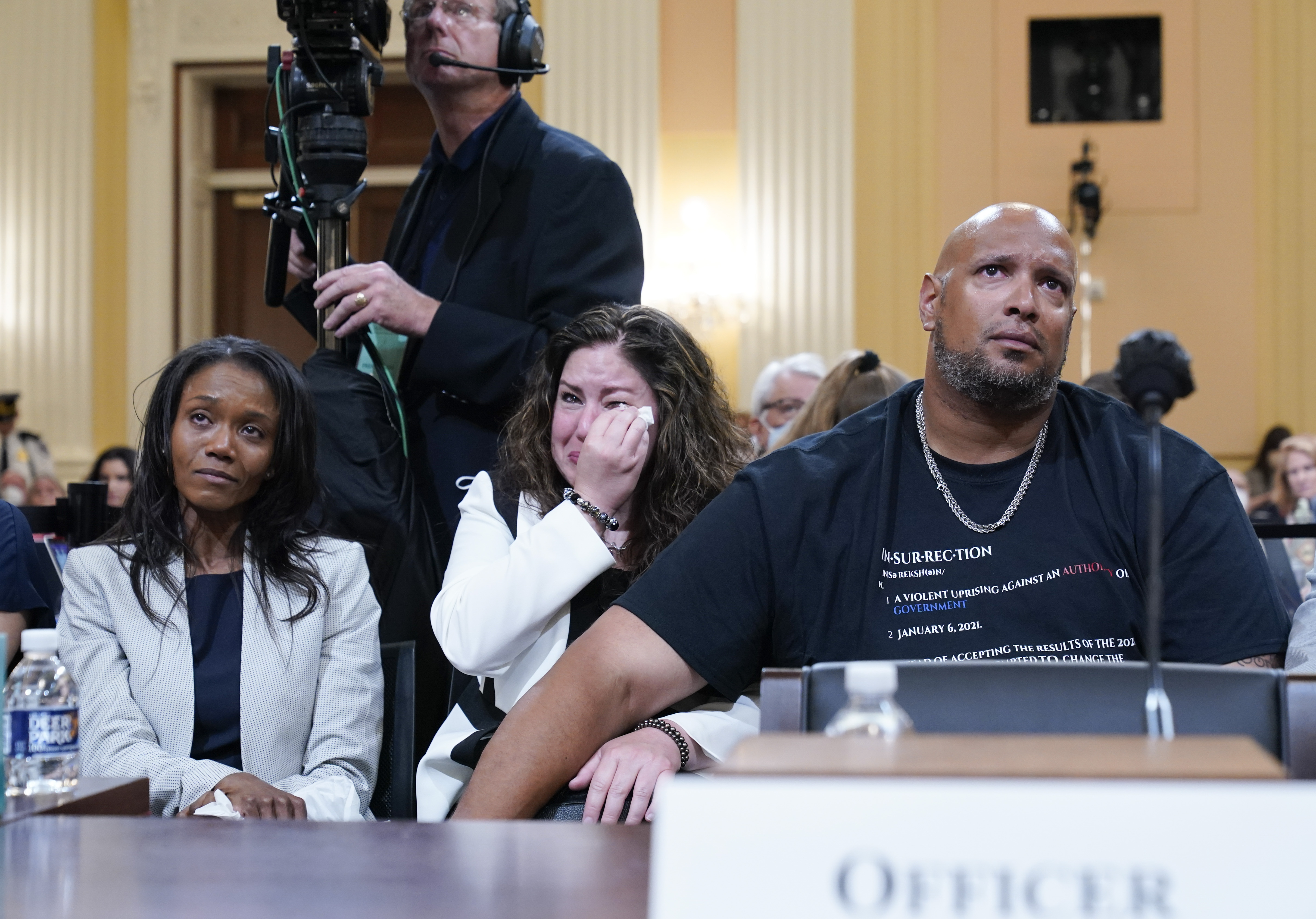 US Capitol Police Sargent Harry Dunn, right, Sandra Garza, the longtime partner of fallen Capitol Police Officer Brian Sicknick, center, and Serena Liebengood, widow of Capitol Police officer Howie Liebengood, left, react as a video of the January 6 attack on the US Capitol is played during a public hearing.