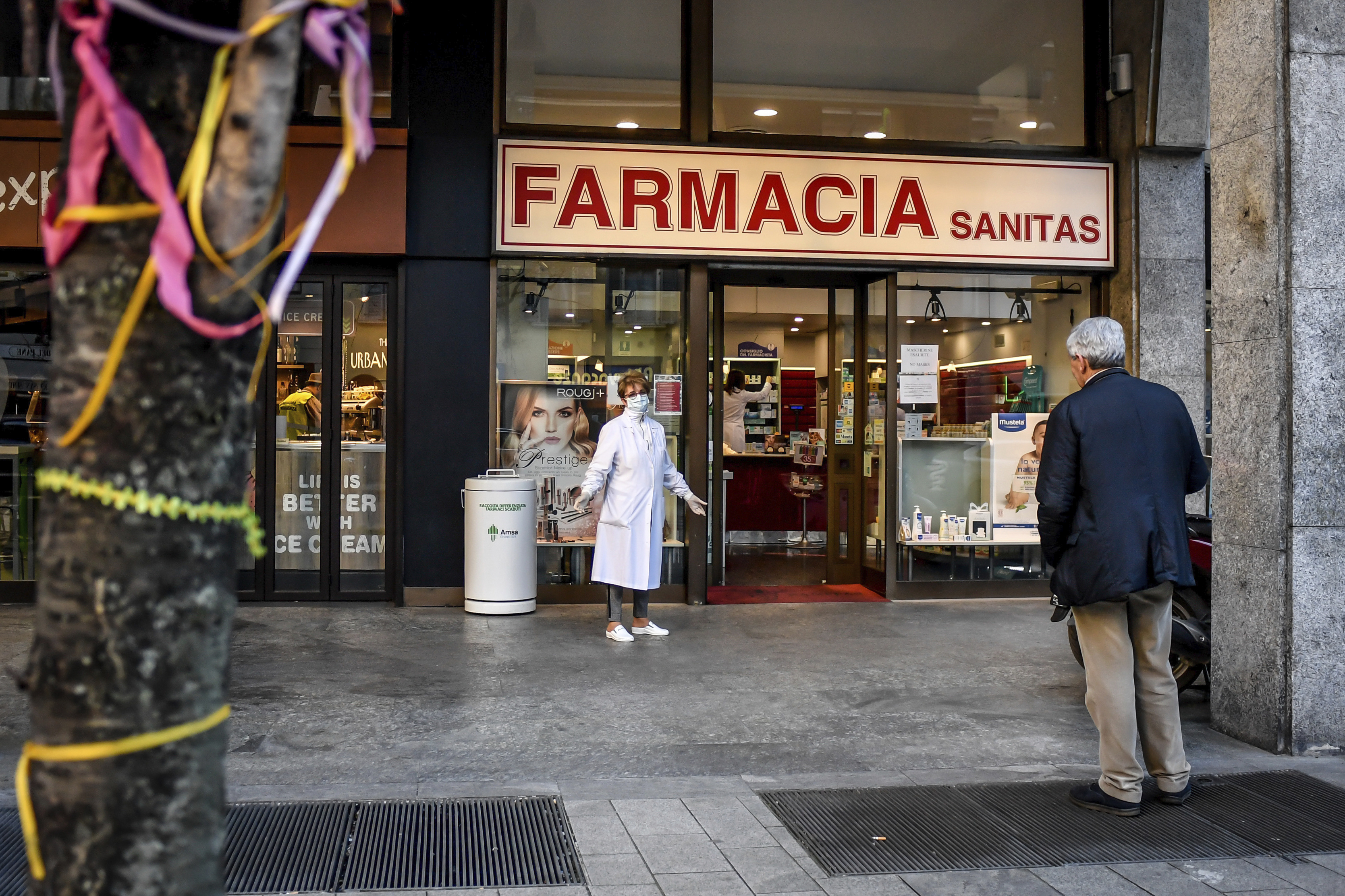 A pharmacist wears a mask as she speaks to a man keeping his distance, outside a pharmacy in Milan, Italy, Wednesday, March 11, 2020. Picture: Claudio Furlan