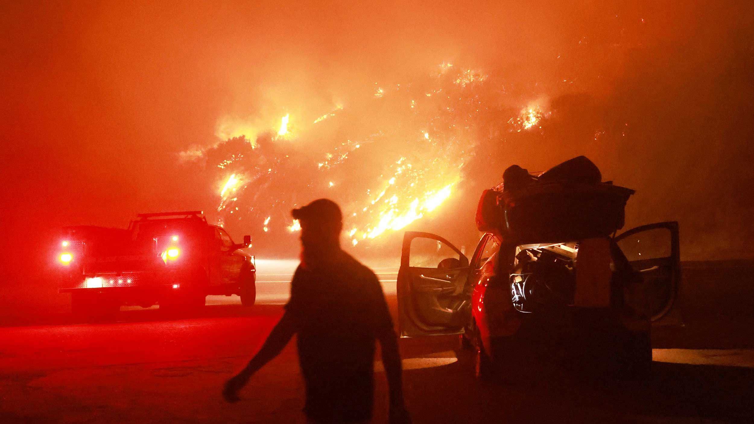 Un residente camina junto a su automóvil repleto de pertenencias mientras la autopista 330 es devorada por el incendio Line cerca de Running Springs, California, el 7 de septiembre.