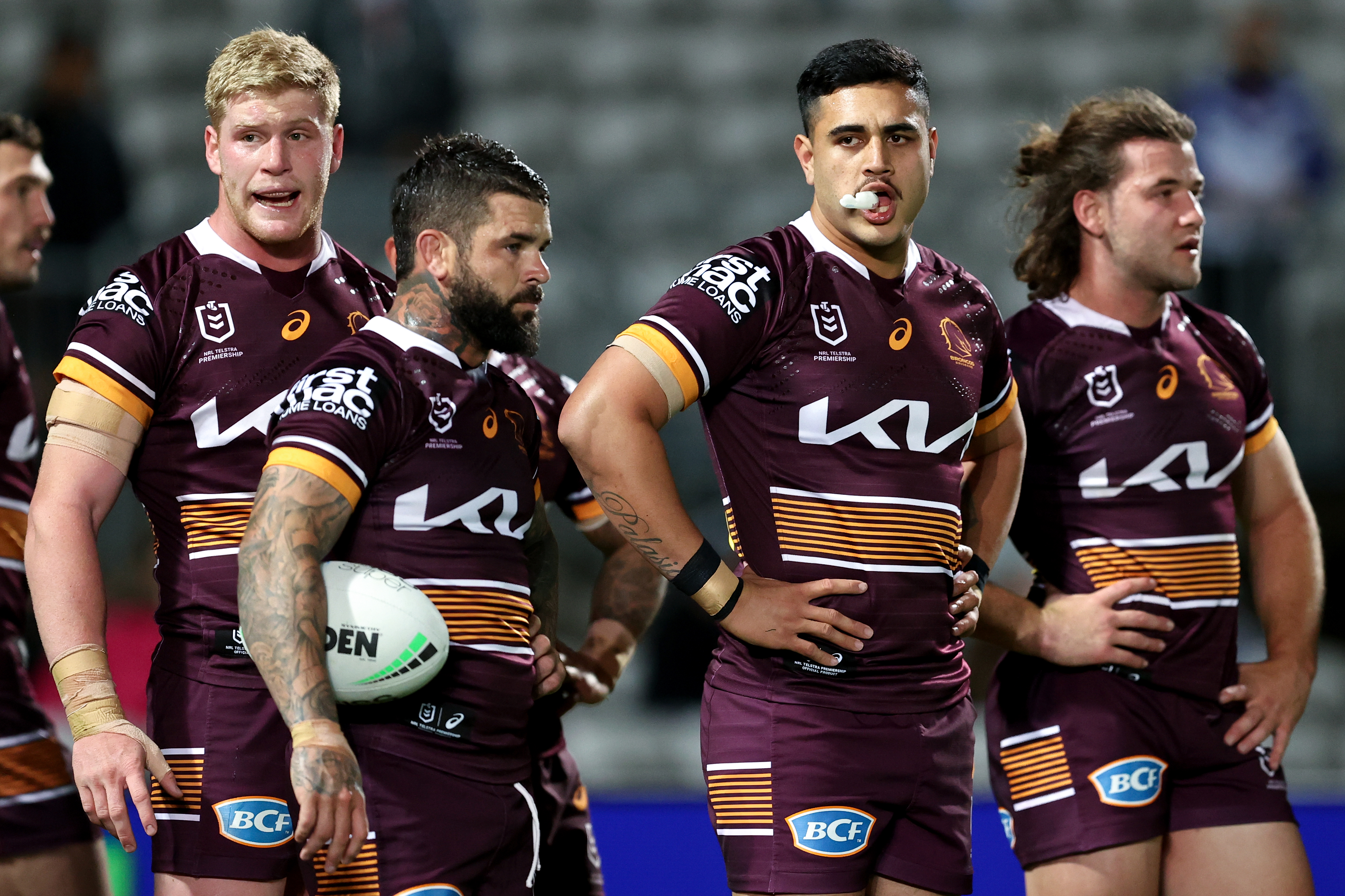Broncos players react to a loss against the Dragons.