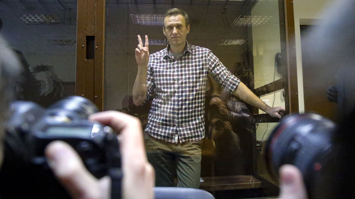 Opposition leader Alexei Navalny stands in a cage in the Babuskinsky District Court in Moscow, Russia, Saturday, Feb. 20, 2021. 