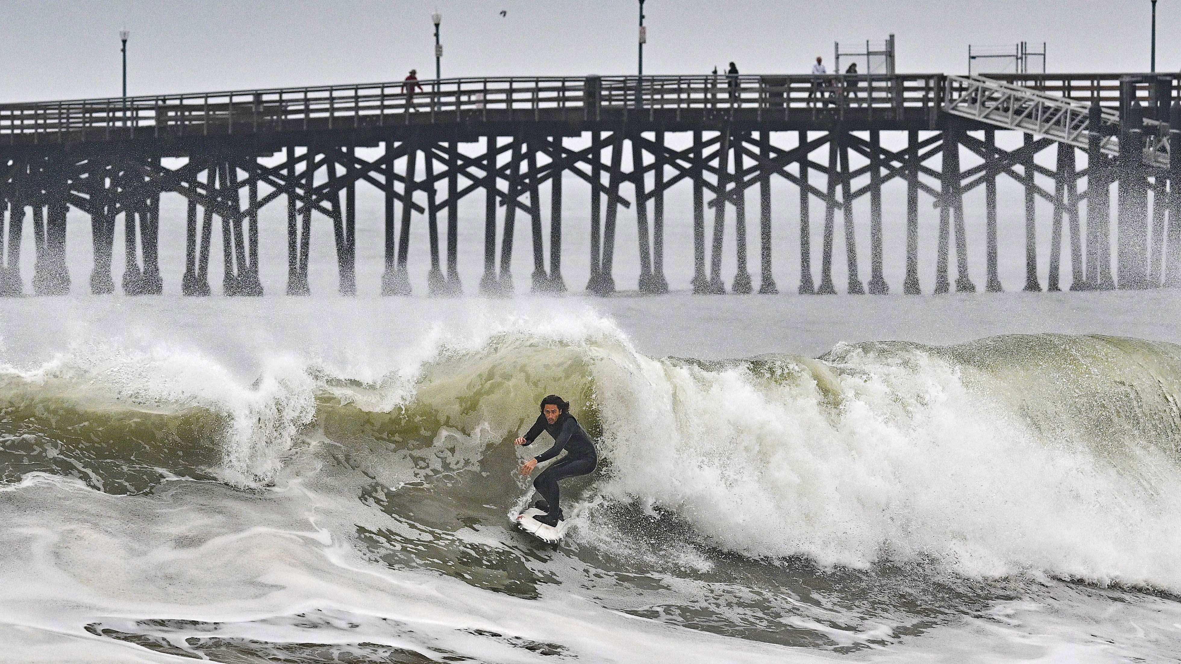 Un surfista monta una ola en Seal Beach, California, el lunes 23 de diciembre de 2024. (Jeff Gritchen/The Orange County Register vía AP)