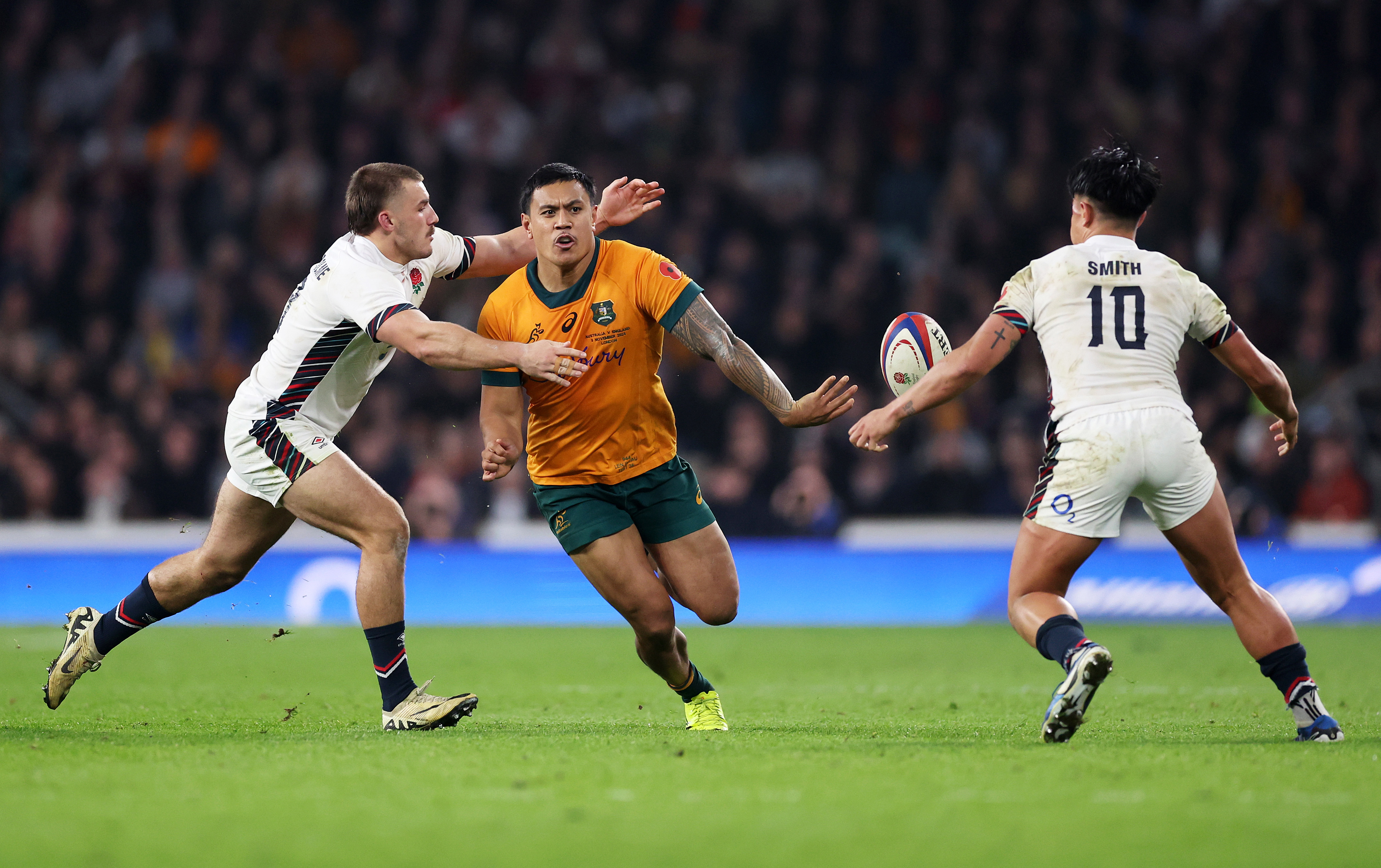 Len Ikitau of Australia passes the ball under pressure from Ollie Sleightholme of England.