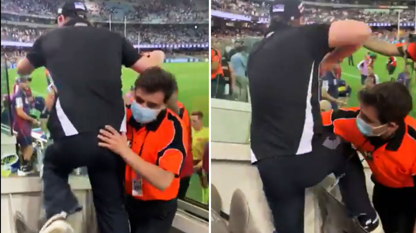 An unruly fan was restrained as he tried to get at umpires. (Twitter)