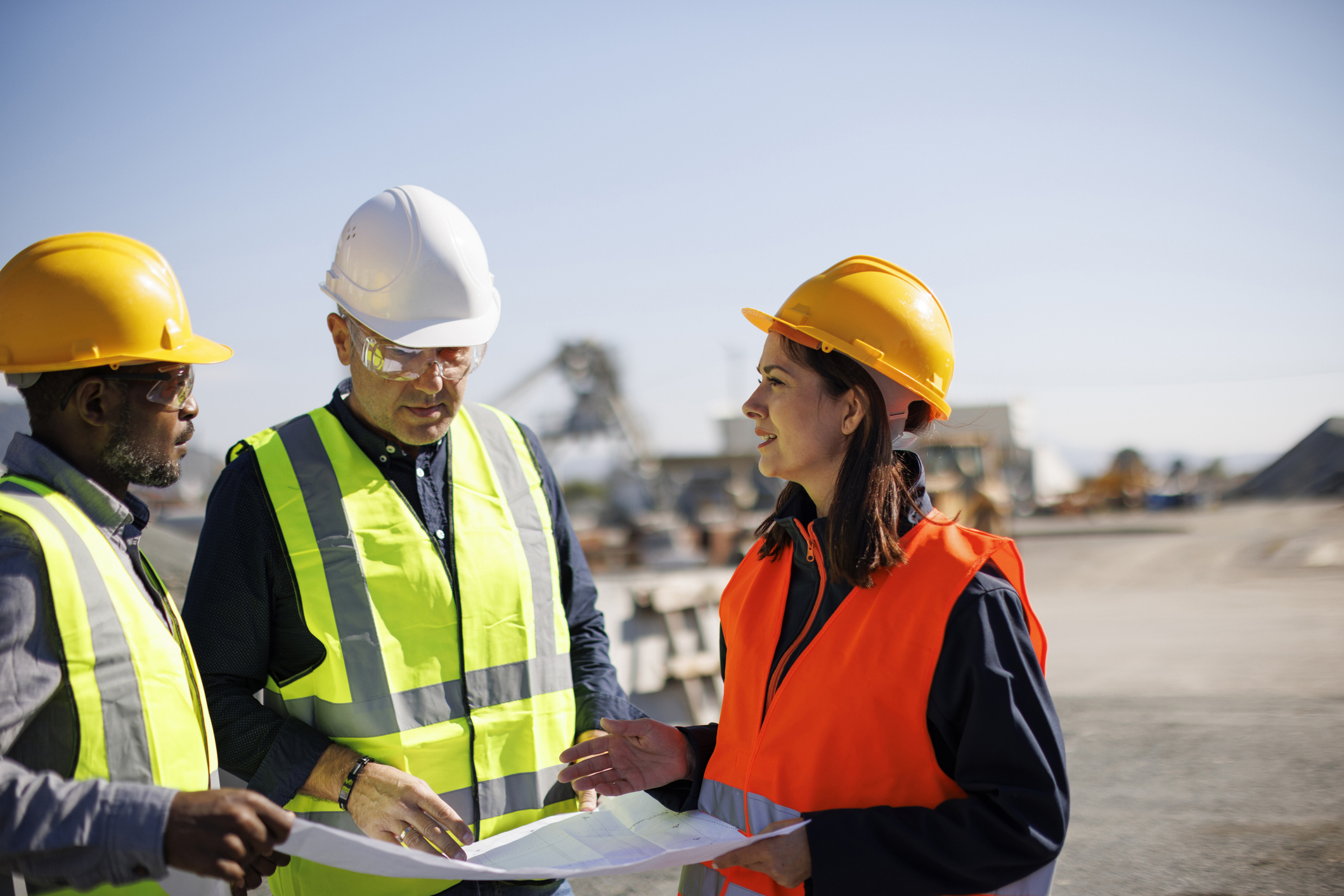 Engineers and architect discussing building plan at construction site