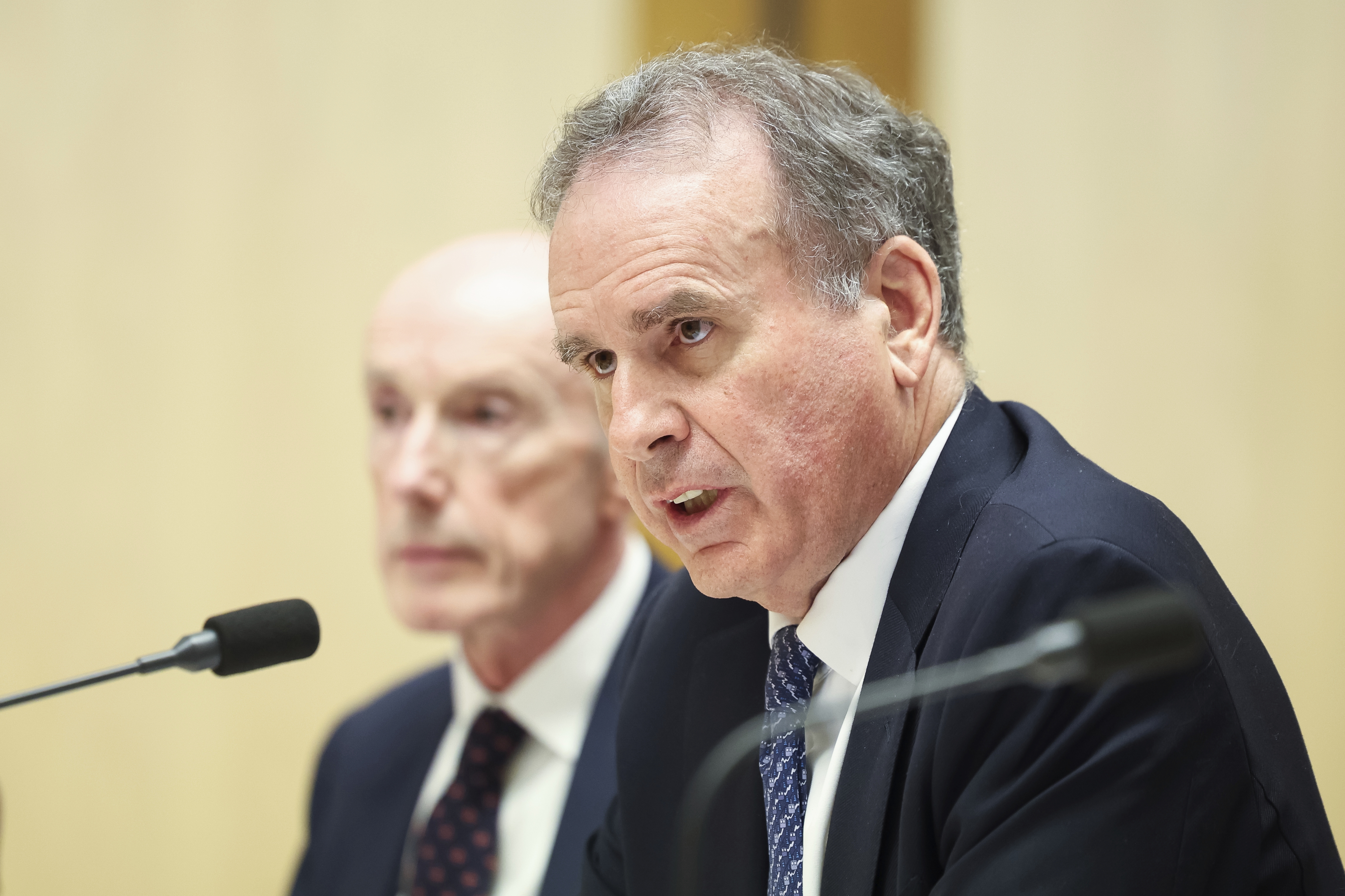 Paul O'Sullivan, former Chairman, and John Arthur, Chairman, from Optus,  during the Triple Zero service outage hearing with the Senate Environment and Communications References Committee, at Parliament House in Canberra on Monday 3 November 2025.