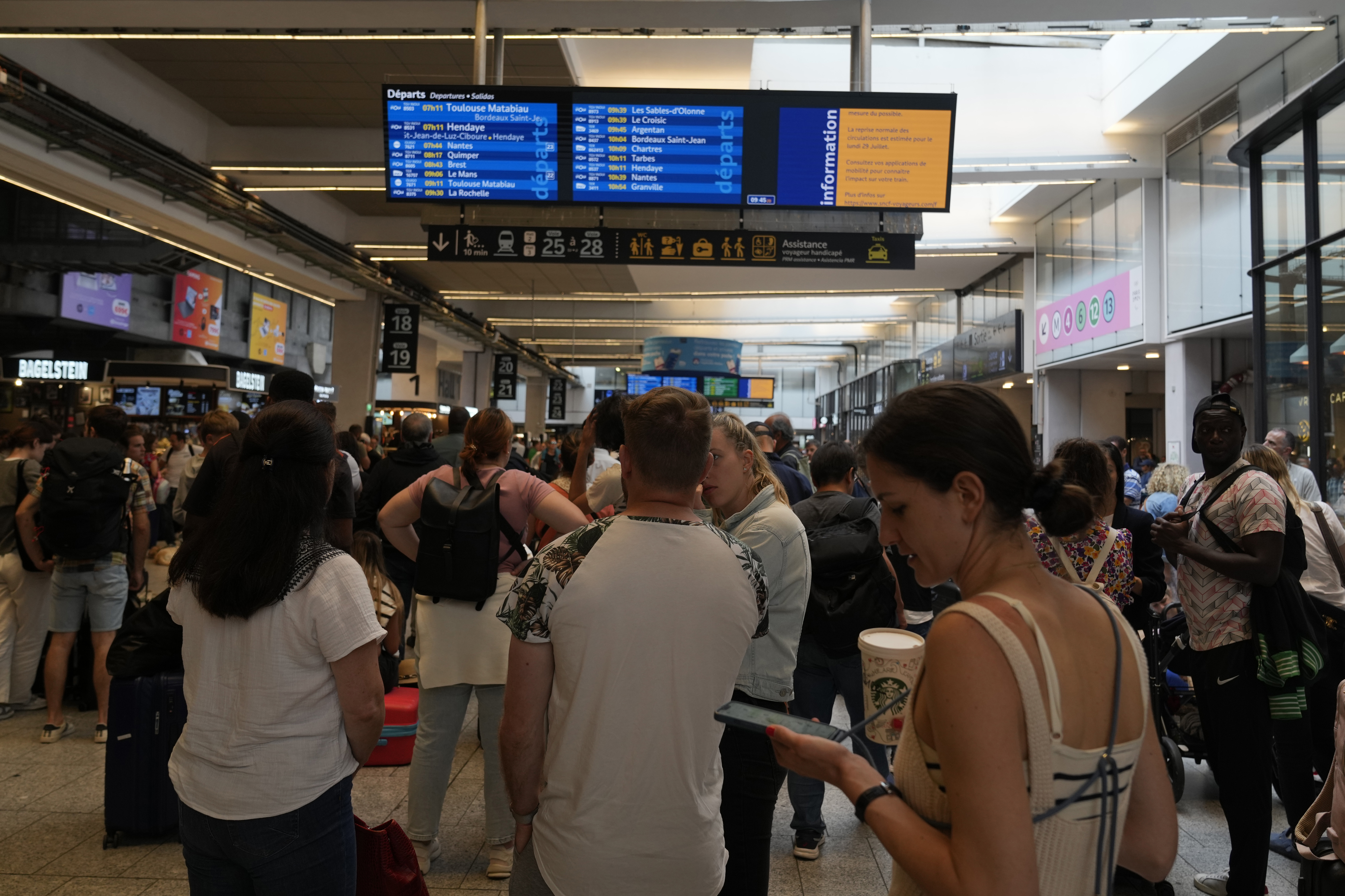 Travellers check trains on an electronic board at the Gare de Montparnasse, at the 2024 Summer Olympics, Friday, July 26, 2024, in Paris, France. 