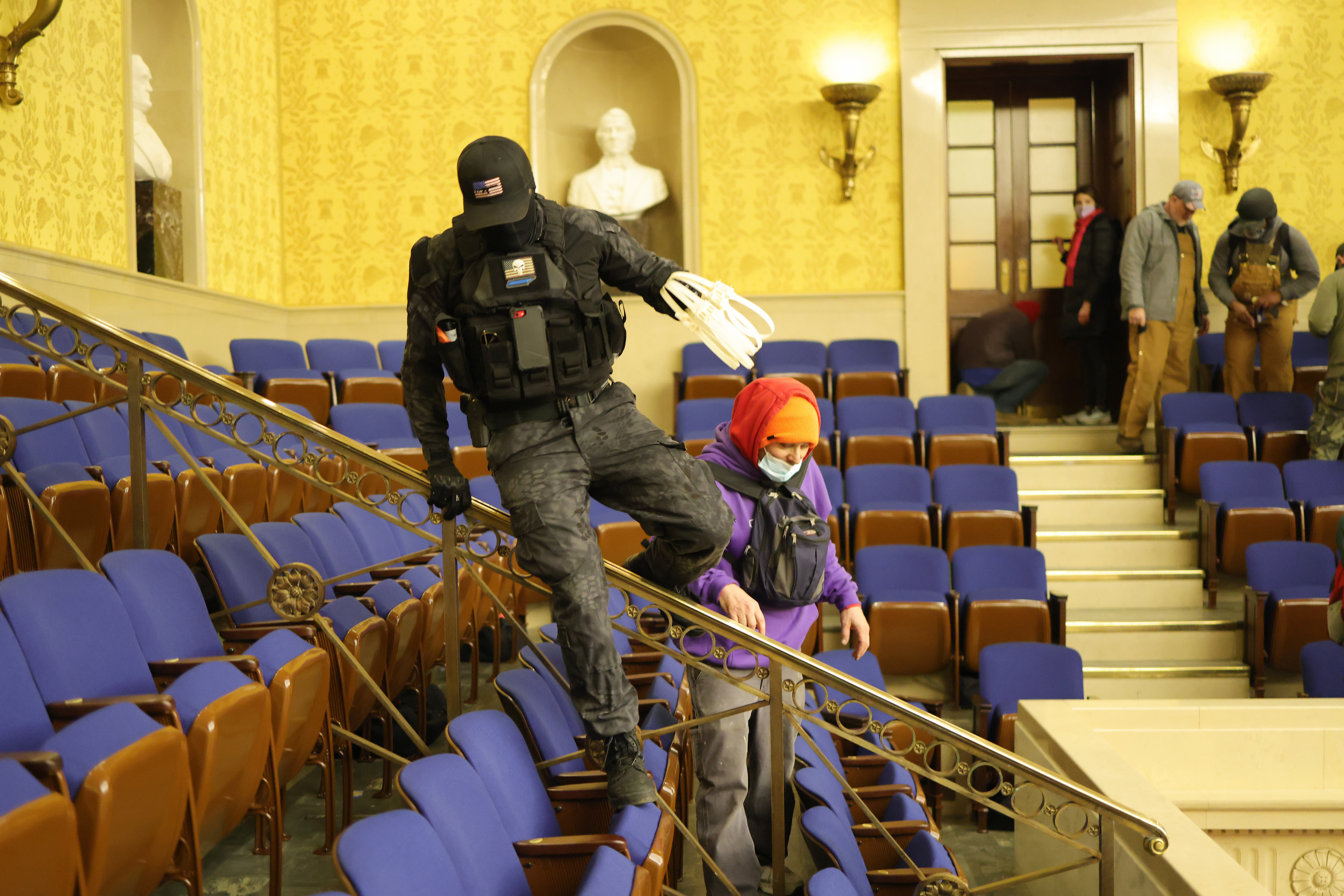 A protester carrying plastic zip-tie handcuffs is seen inside the Senate chamber, prompting theories some who stormed the building were ready and willing to capture hostages.