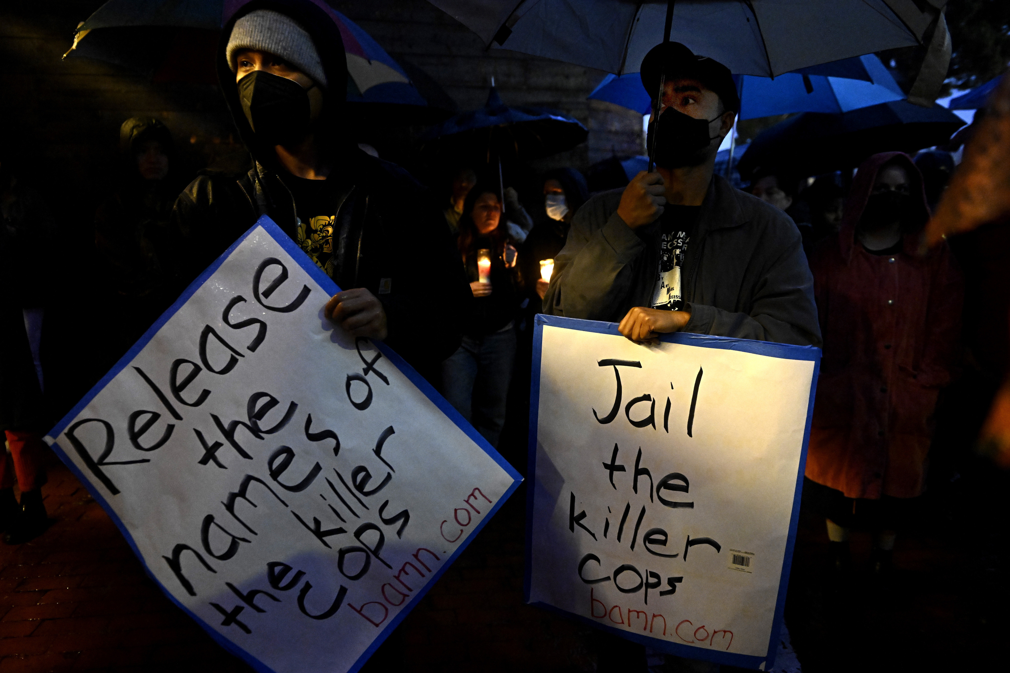 People hold up signs asking for the release of the LAPD officers names that were involved and for them to be jailed during a vigil in Los Angeles on Saturday, Jan. 14, 2023, for Keenan Anderson.