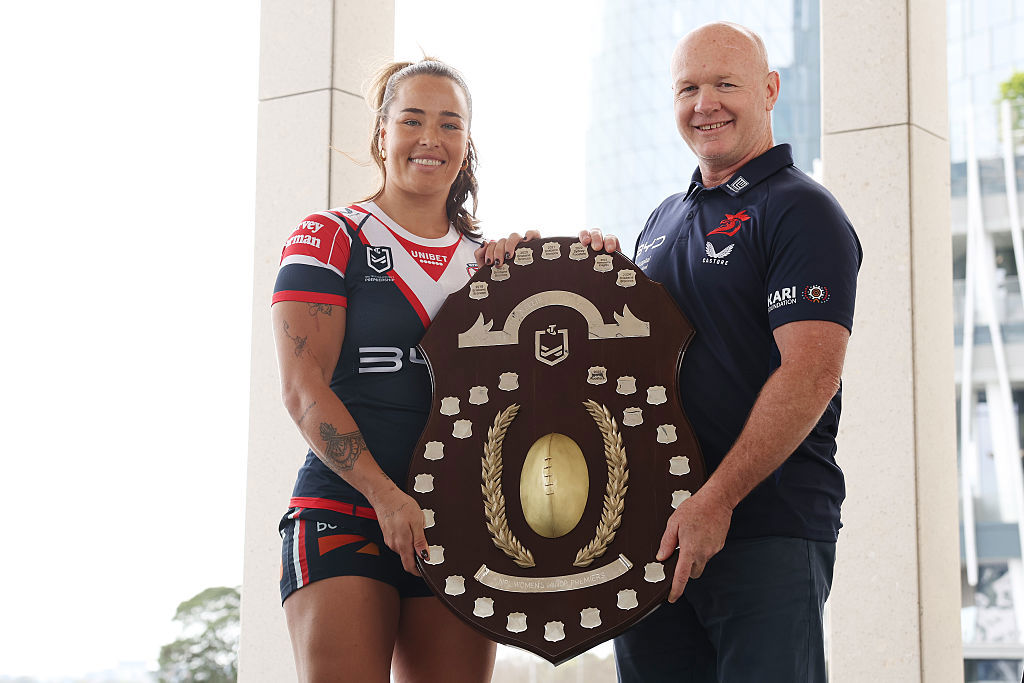 Isabelle Kelly of the Roosters and Roosters head coach John Strange pose with the premiership trophy.
