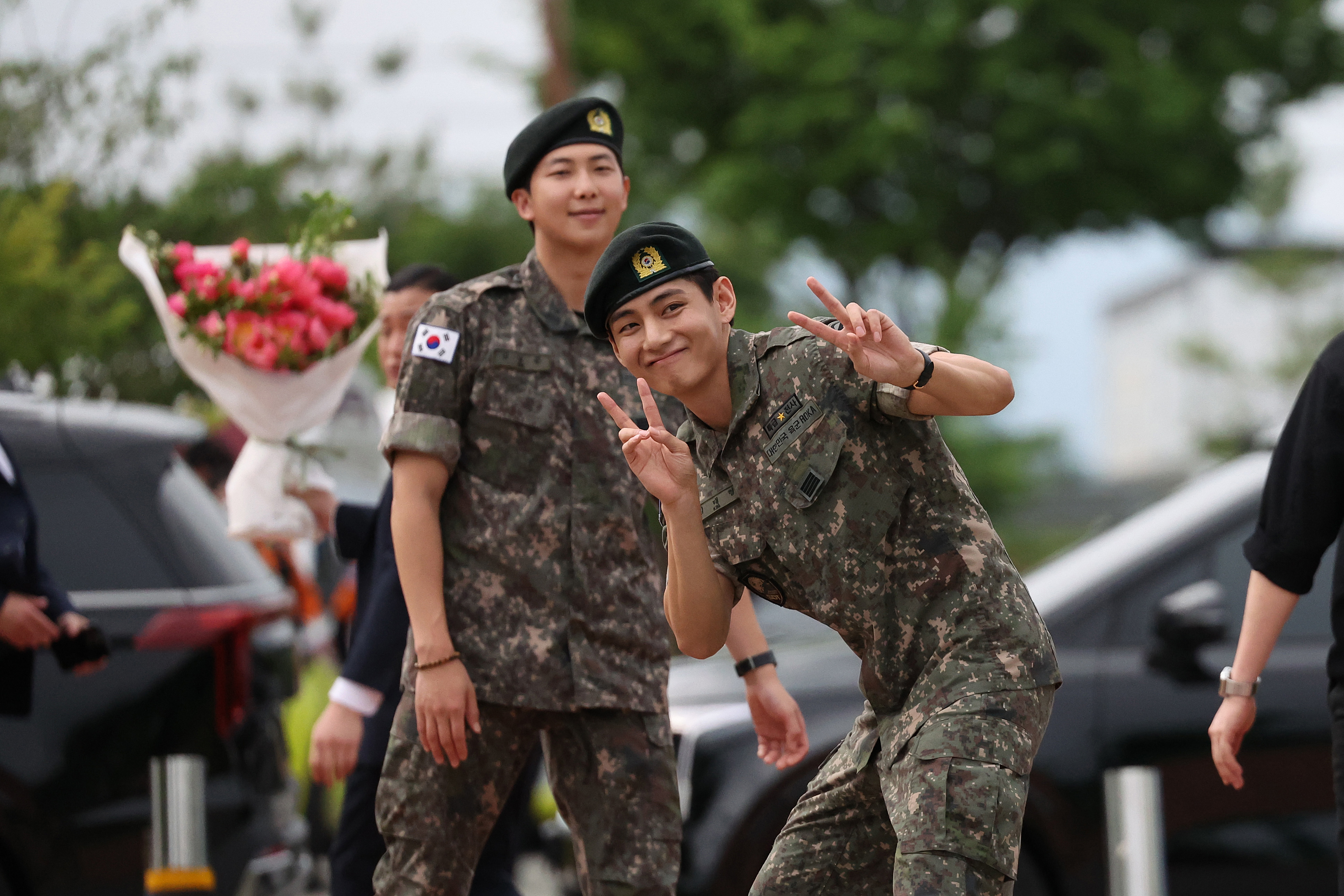 K-pop band BTS's members RM (L) and V (R) react after being discharged from a mandatory military service