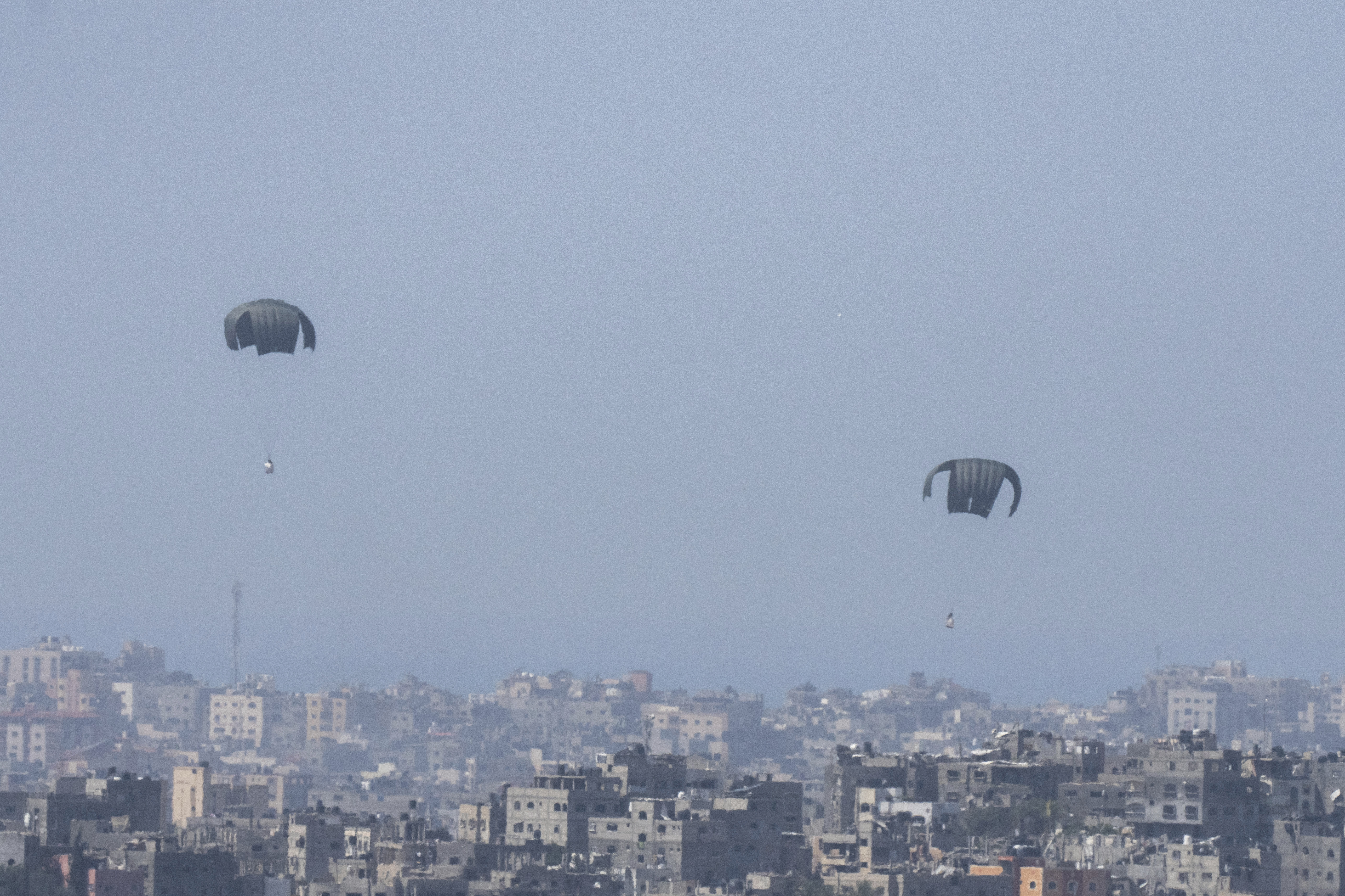 Parachutes drop supplies into the northern Gaza Strip, as seen from southern Israel, Thursday, March 21, 2024 