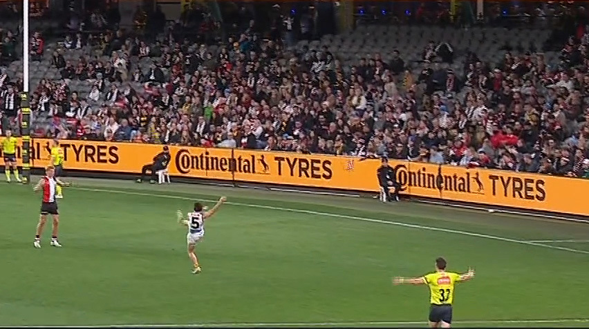 Nick Watson kicks for goal as the umpire calls play on.