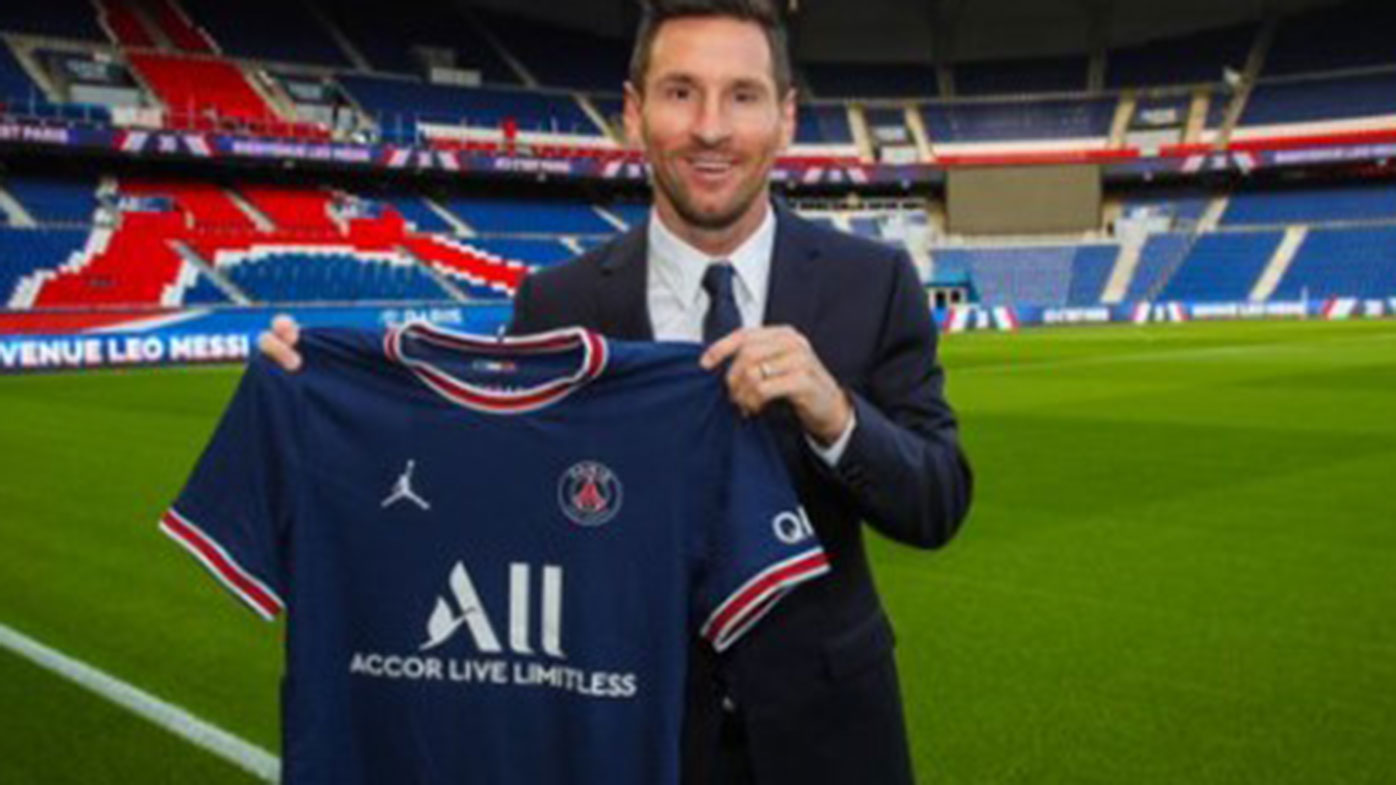 Lionel Messi poses with his new Paris Saint-Germain jersey.
