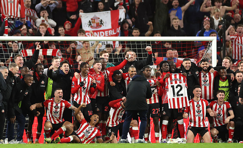 The Sunderland players celebrate victory with a team picture on the pitch.