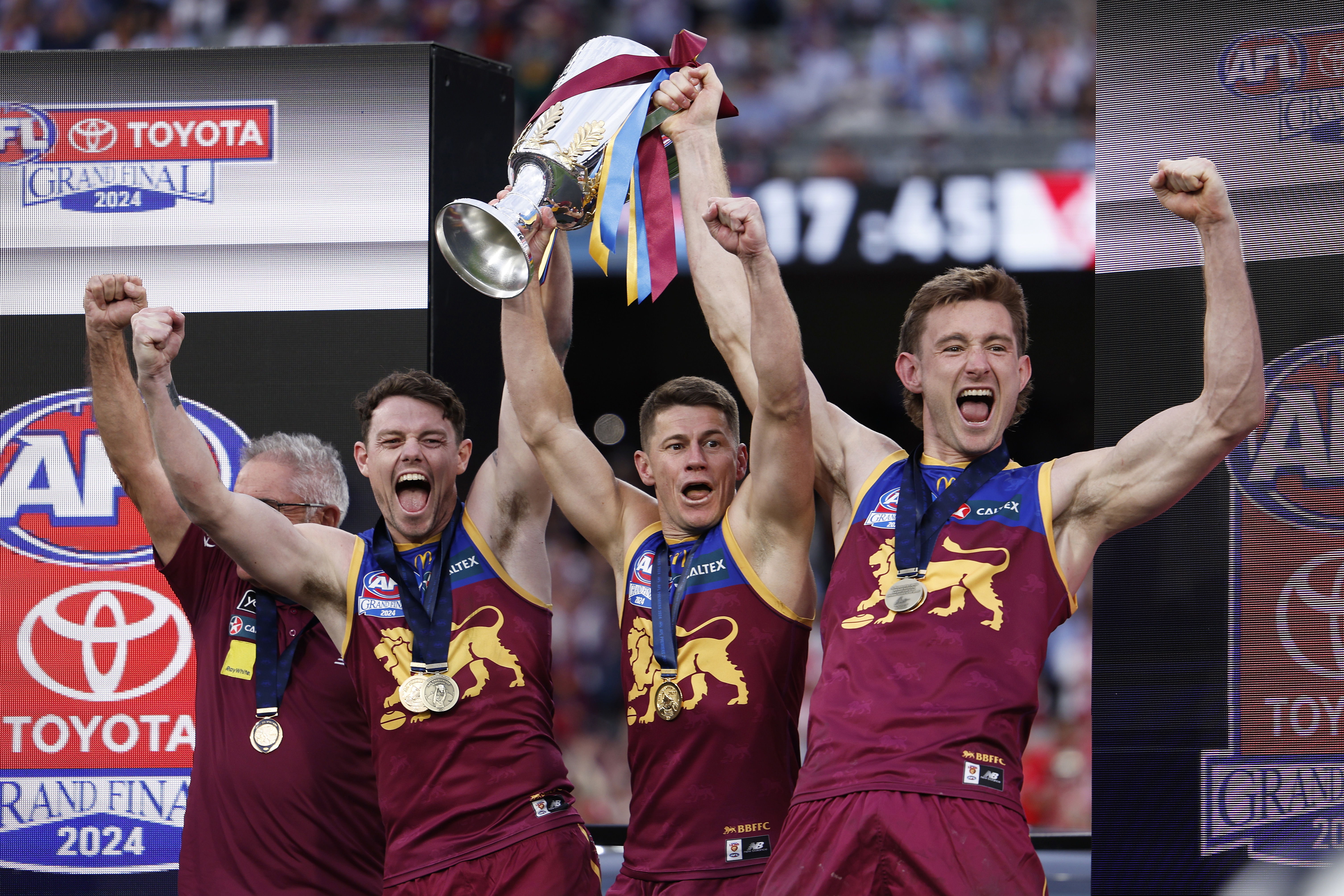 Chris Fagan, Lachie Neale, Dayne Zorko and Harris Andrews hold the 2024 premiership cup.
