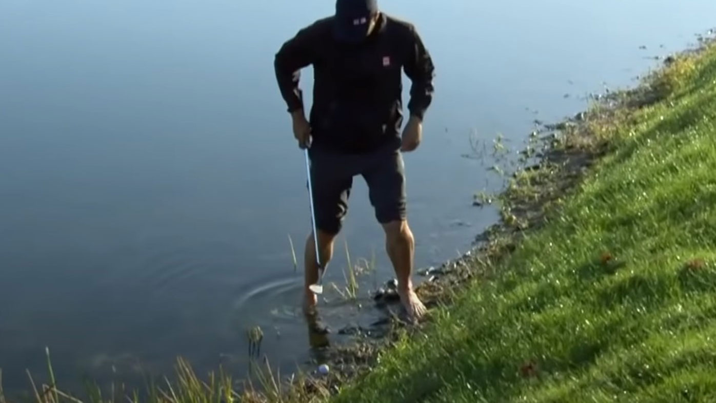 Adam Scott prepares to play from the water during the opening round of the PGA Tour's Honda Classic.