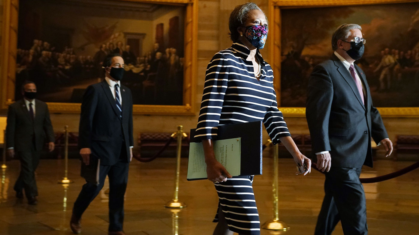 Clerk of the House Cheryl Johnson along with acting House Sergeant-at-Arms Tim Blodgett, lead the Democratic House impeachment managers as they walk through the Capitol Rotunda in the Capitol, to deliver to the Senate the article of impeachment alleging incitement of insurrection against former President Donald Trump, Monday, Jan. 25, 2021 in Washington