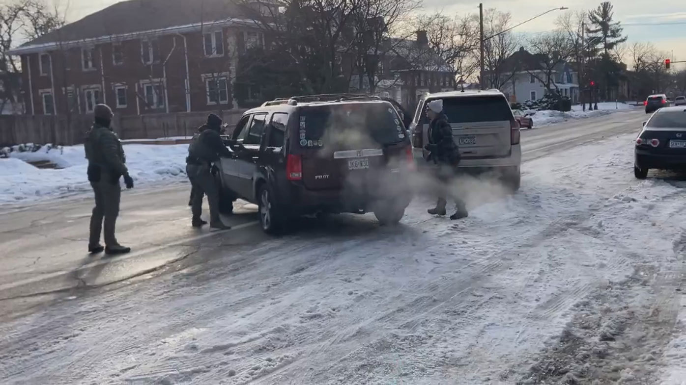 An ICE agent grabs the door handle of her car moments before the shooting.