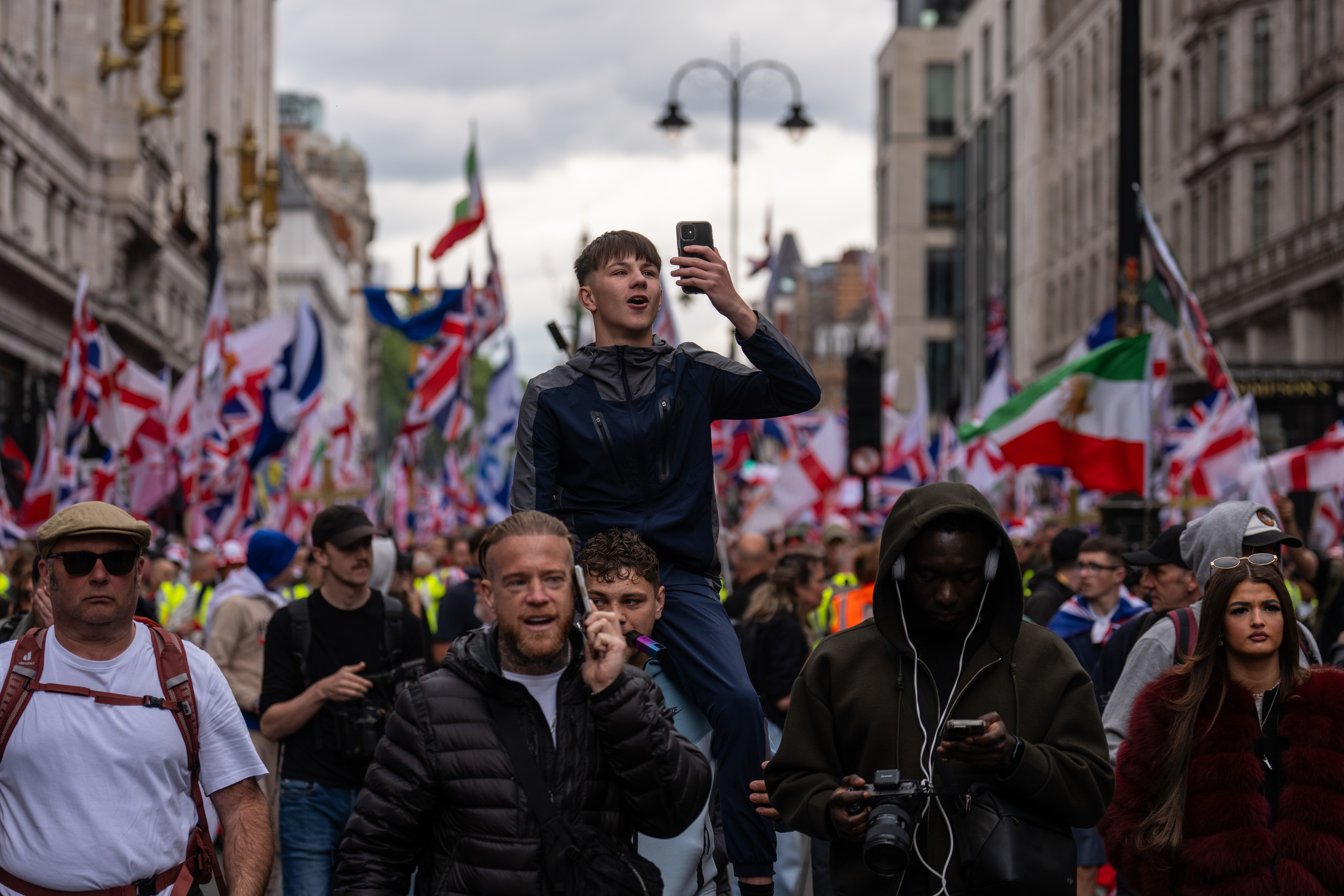 LONDON, ENGLAND - MAY 16: People take part in the "Unite the Kingdom" rally on May 16, 2026 in London, England. The far-right "Unite the Kingdom" rally, organised by Tommy Robinson is to be held under strict Public Order Act conditions with demonstrators legally confined to a specific south-bound corridor from Kingsway to Parliament Square between late morning and early evening. To prevent clashes with a concurrent counter-protest, the Metropolitan Police has launched an unprecedented £4.5 milli