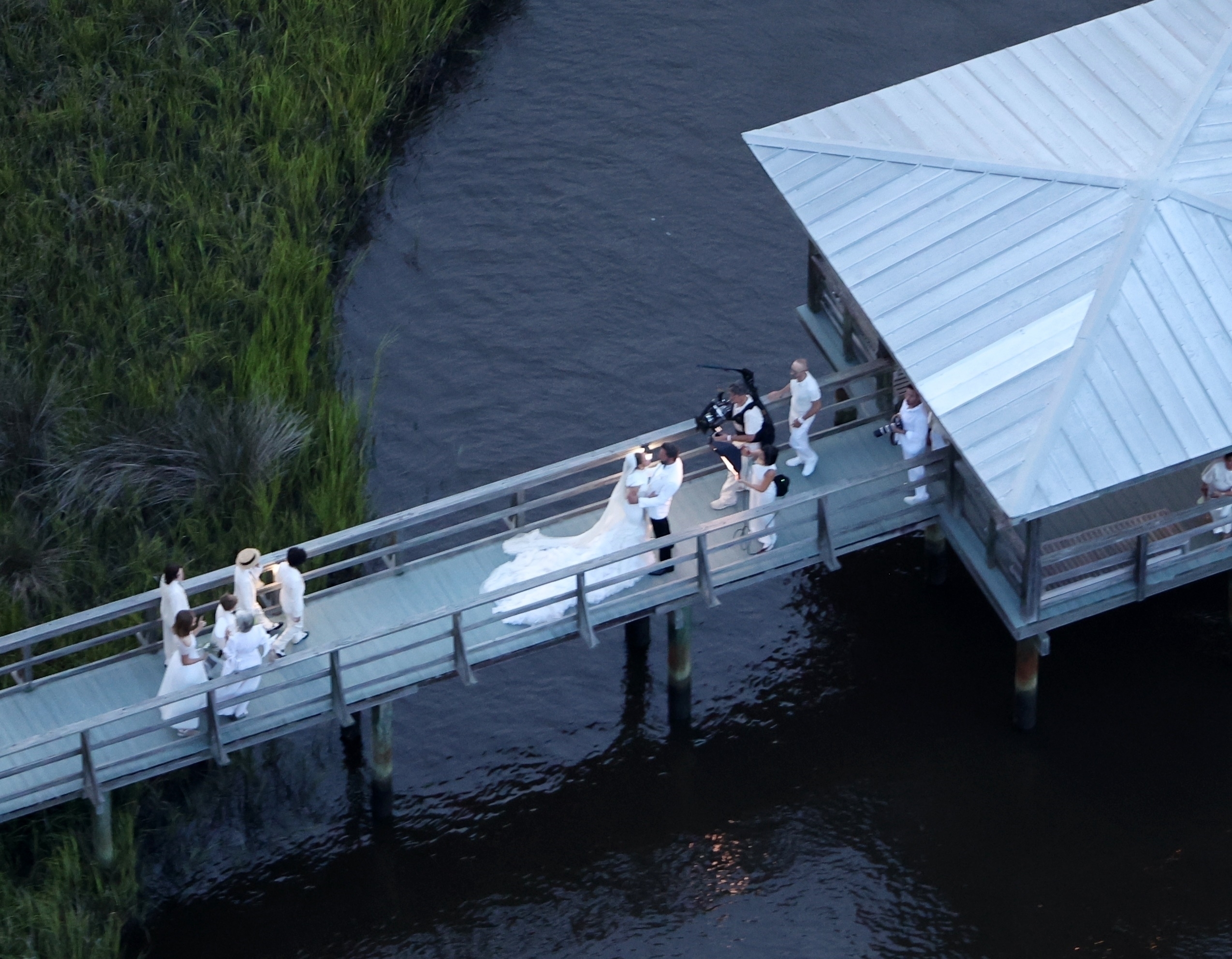 Jennifer Lopez wears a stunning white wedding dress as she celebrates her marriage to Ben Affleck, suitably dashing in a white jacket and black pants. The couple kissed and posed for pics around Bens $8million Georgia mansion on Saturday evening before spending the night celebrating their love and their union with family and a raft of A-list friends.