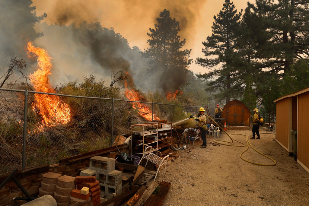 San Bernardino County firefighters work to save a home in Wrightwood.