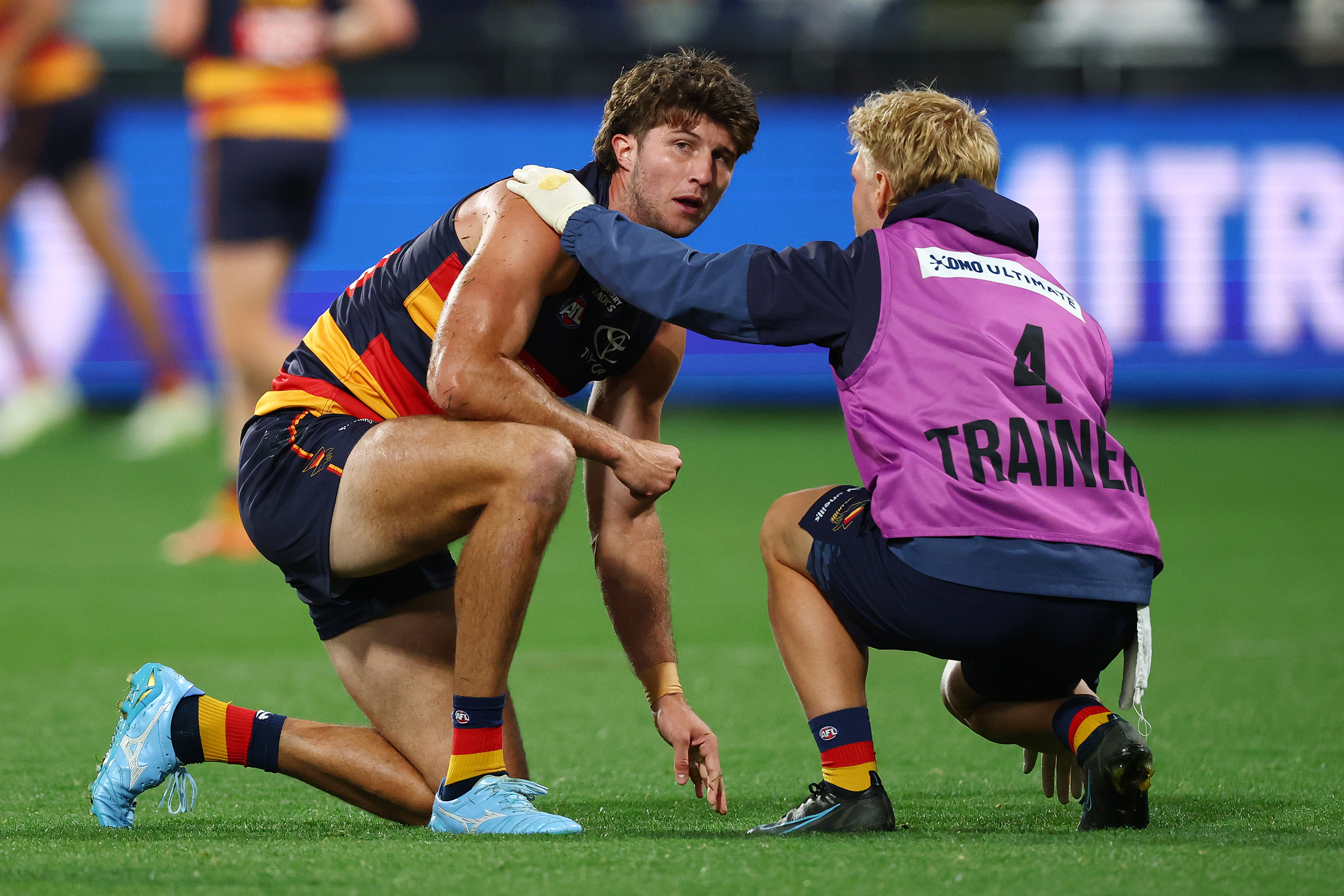 Jordon Butts of the Crows receives medical attention.
