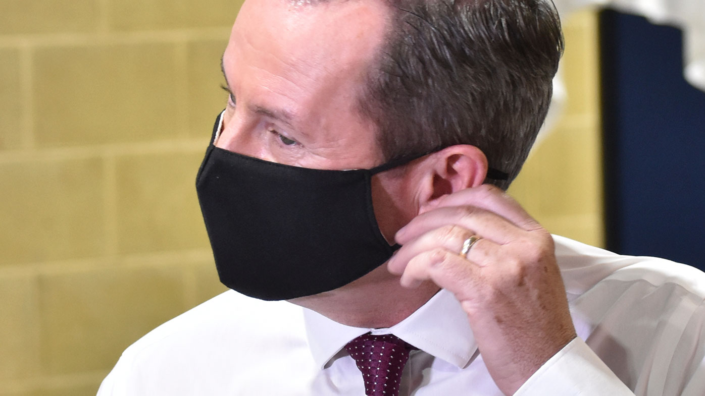 WA Premier Mark McGowan takes off his mask.