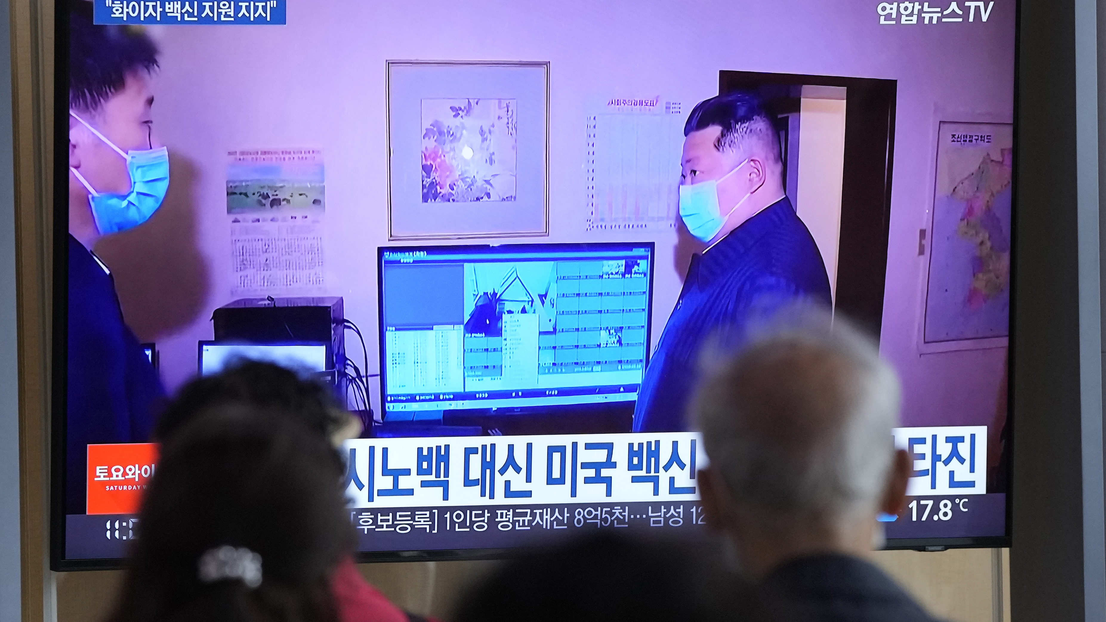 People watch a TV screen showing a file image of North Korean leader Kim Jong Un, right, during a news program at a train station in Seoul, South Korea,
