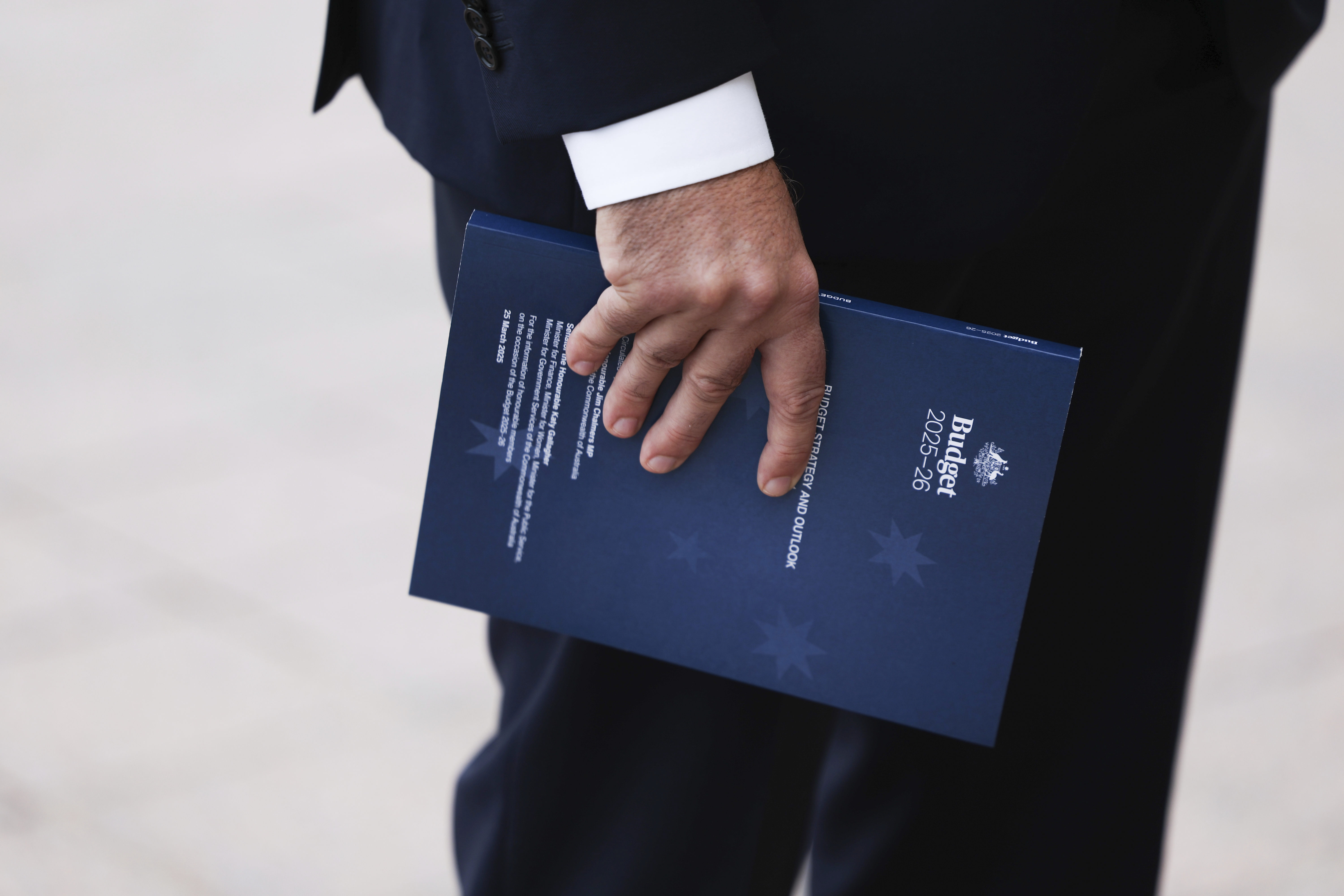 Budget documents in the hand of Treasurer Dr Jim Chalmers during a doorstop interview ahead of handing down the 2025-26 Federal Budget, at Parliament House in Canberra on Tuesday 25 March 2025.