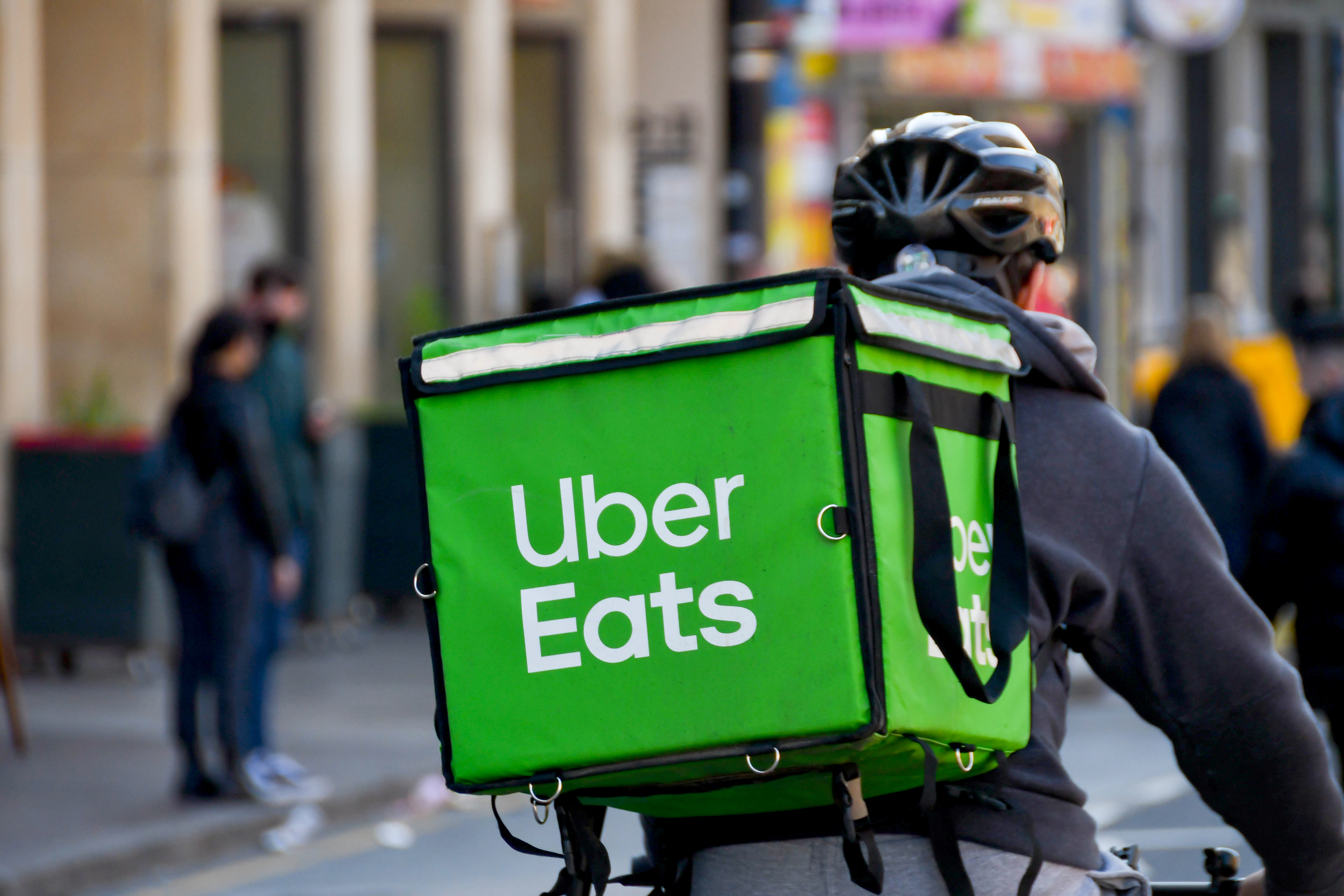Cardiff, Wales - March 2022: Cycle courier for the Uber Eats food delivery service riding through the city centre