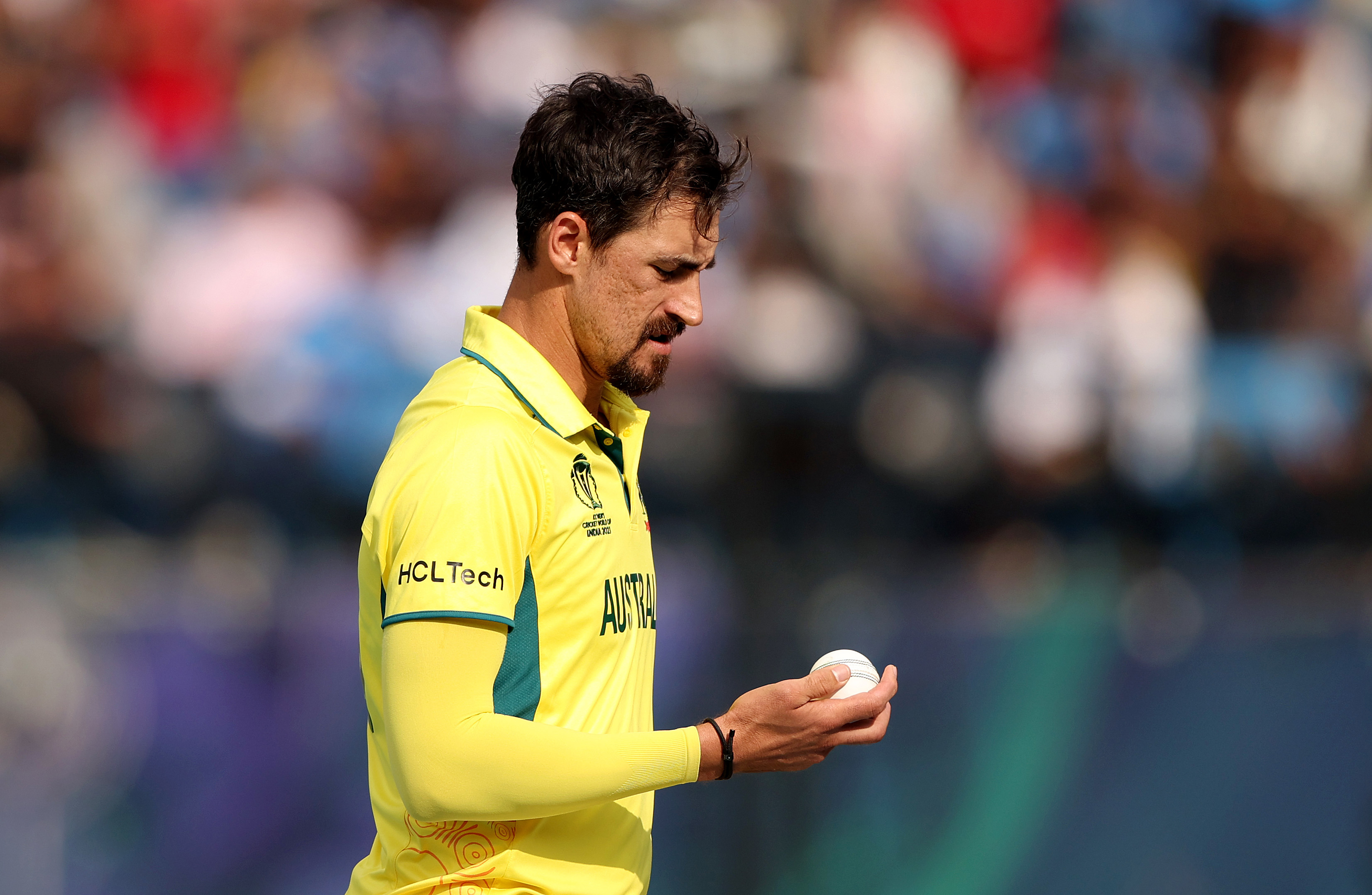 DHARAMSALA, INDIA - OCTOBER 28: Mitchell Starc of Australia inspects the ball during the ICC Men's Cricket World Cup India 2023 Group Stage Match between Australia and New Zealand at HPCA Stadium on October 28, 2023 in Dharamsala, India. (Photo by Robert Cianflone/Getty Images)