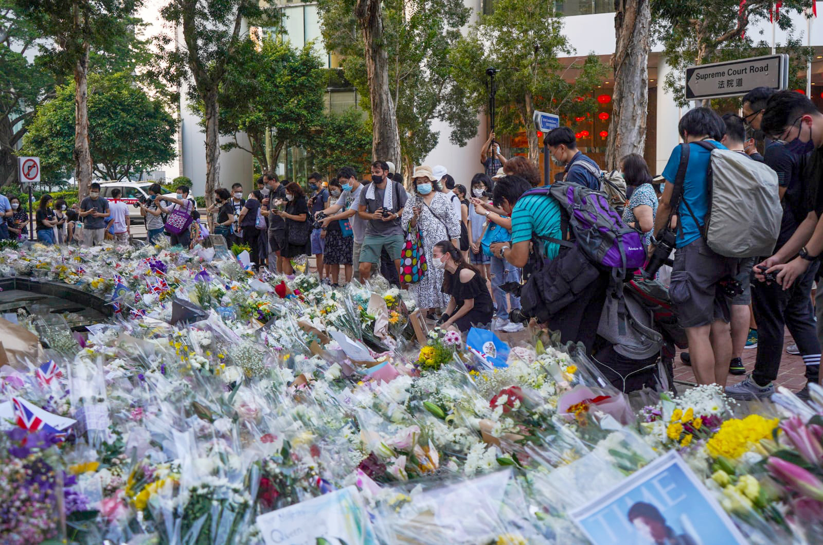 A crying woman kneels down to mourn the death of Queen Elizabeth II outside the British consulate in Hong Kong on September 12.