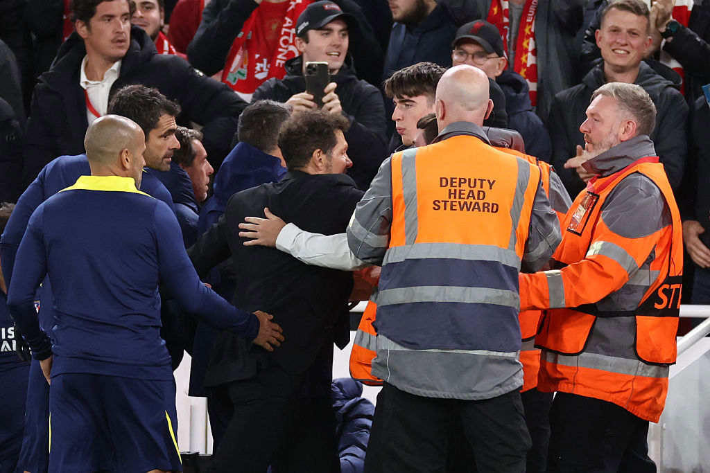 Diego Simeone is restrained as he confronts fans.