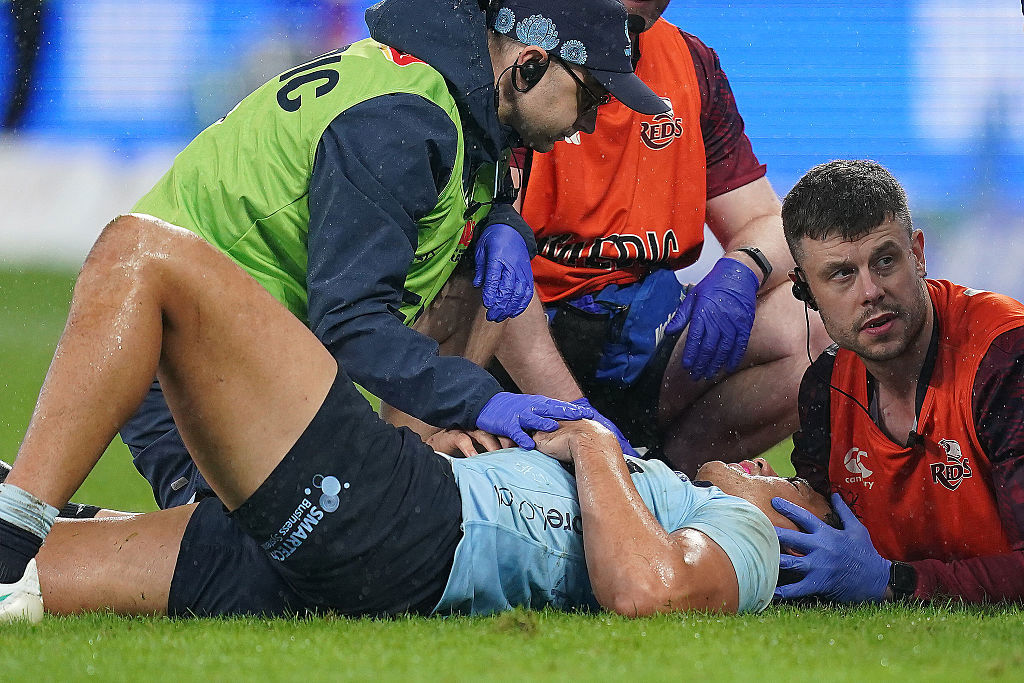 Joseph-Aukuso Suaalii of the Waratahs receives treatment for an injury before being stretchered off.