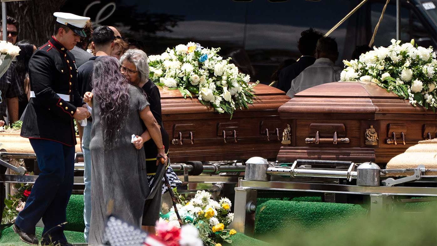 Dos mujeres se consuelan durante el funeral de Irma García y su esposo Joe García en Uvalde, Texas.