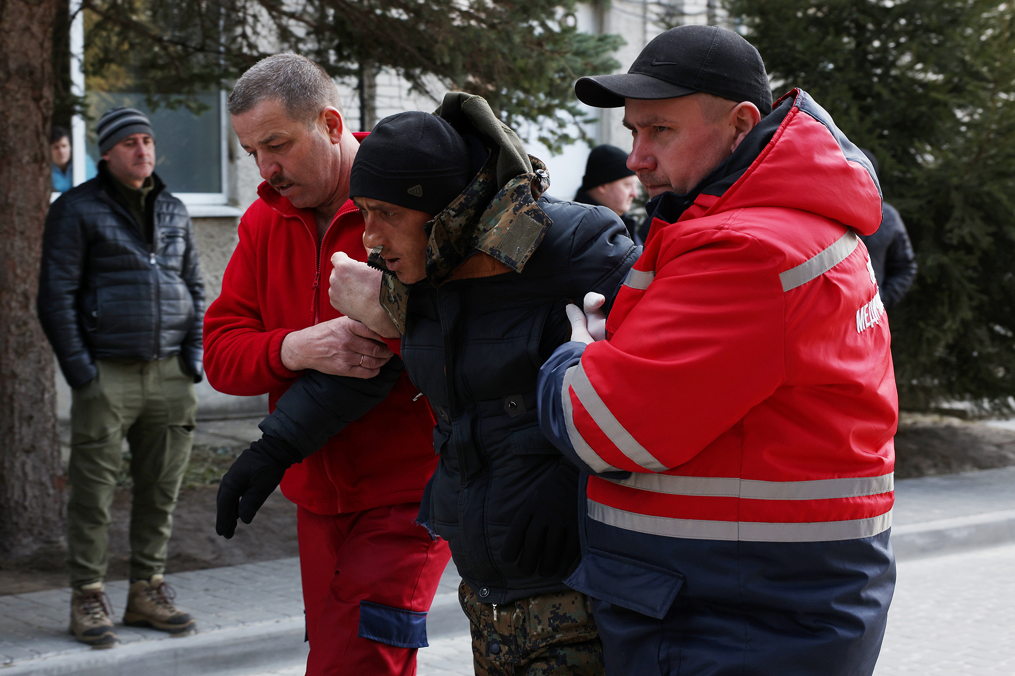 A patient is assisted by medical staff as he arrives at Novoiavorivsk District Hospital on March 13, 2022 in Novoiavorivsk, Ukraine.