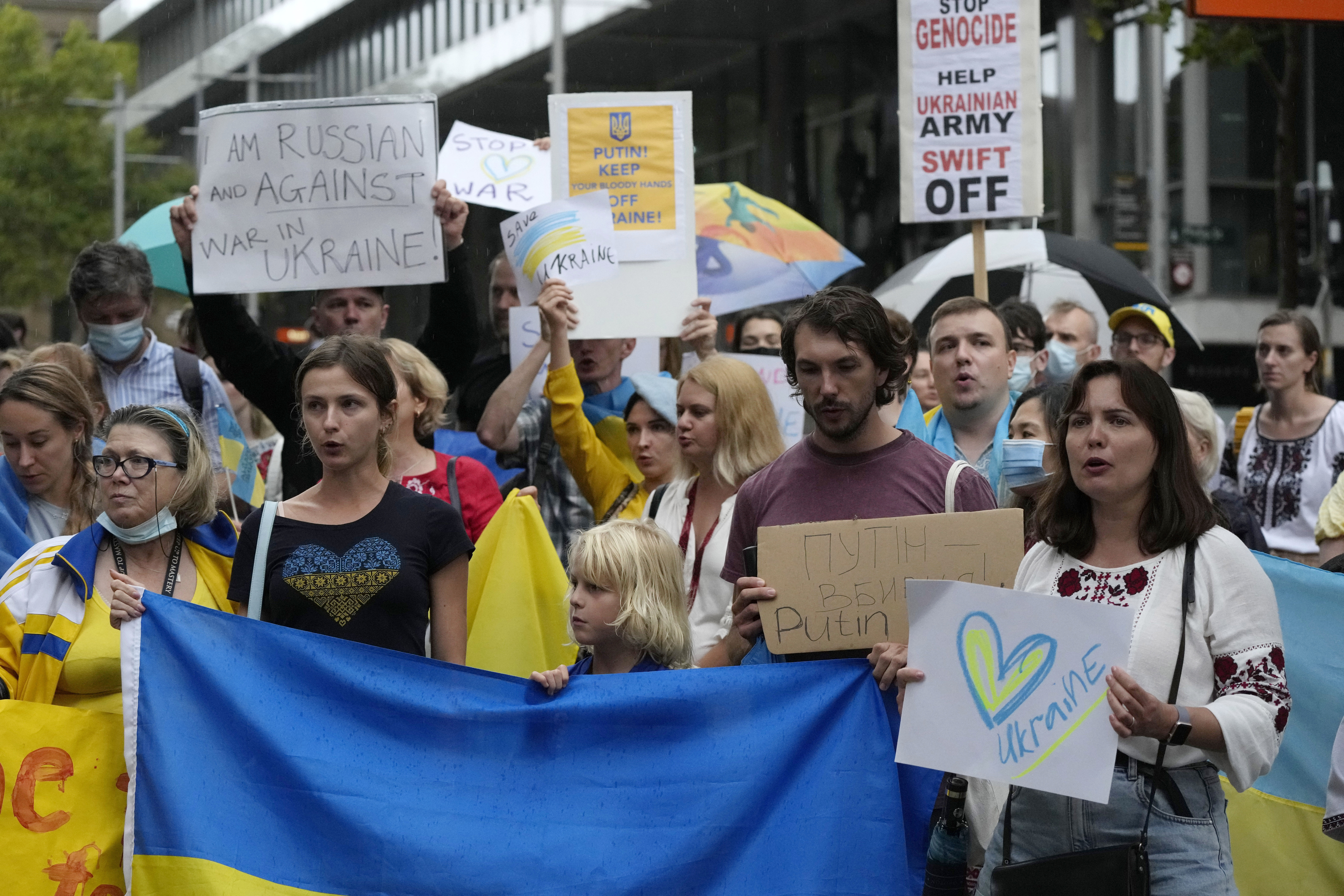 People chant, carry placards and wave Ukrainian flags as they gather in Sydney, Thursday, Feb. 24, 2022, to demonstrate against the attacks in Ukraine. (AP Photo/Rick Rycroft)