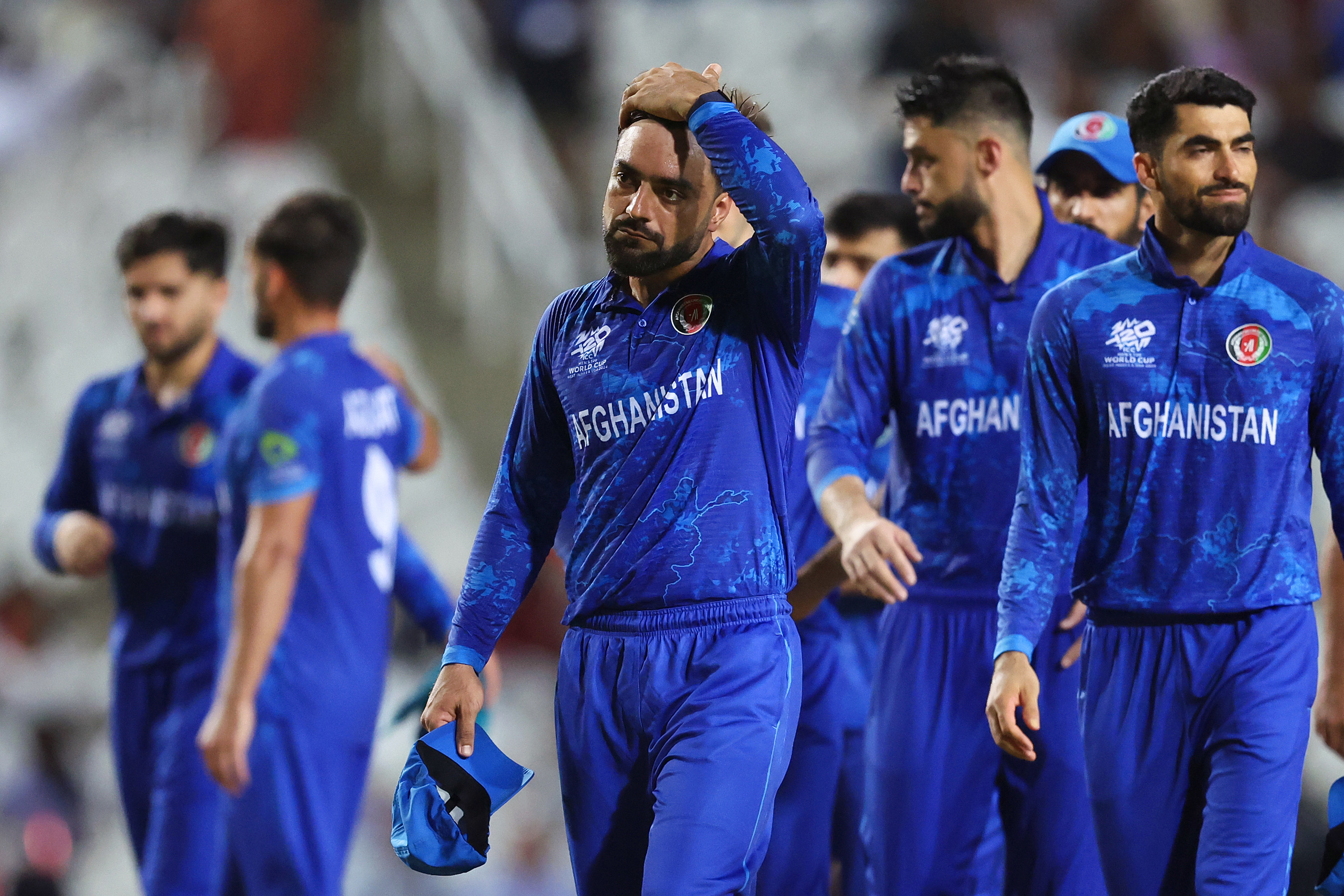 Rashid Khan of Afghanistan looks dejected while leaving the field after the team's defeat in the ICC Men's T20 Cricket World Cup West Indies & USA 2024 Semi-Final match between South Africa and Afghanistan at Brian Lara Cricket Academy on June 26, 2024 in Tarouba, Trinidad And Tobago. (Photo by Robert Cianflone/Getty Images)