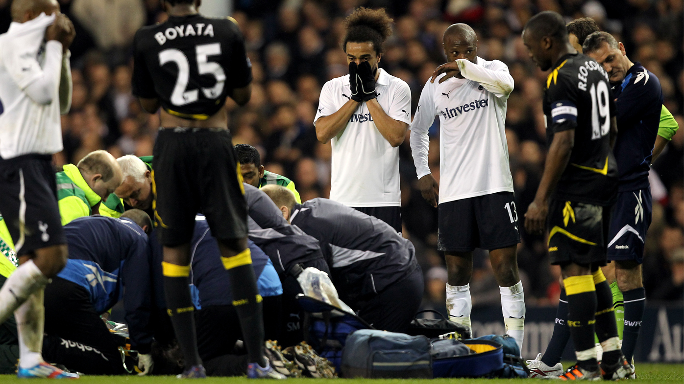Players from both Tottenham Hotspur and Bolton Wanderers watch as Fabrice Muamba of Bolton Wanderers is treated on the pitch after collapsing 