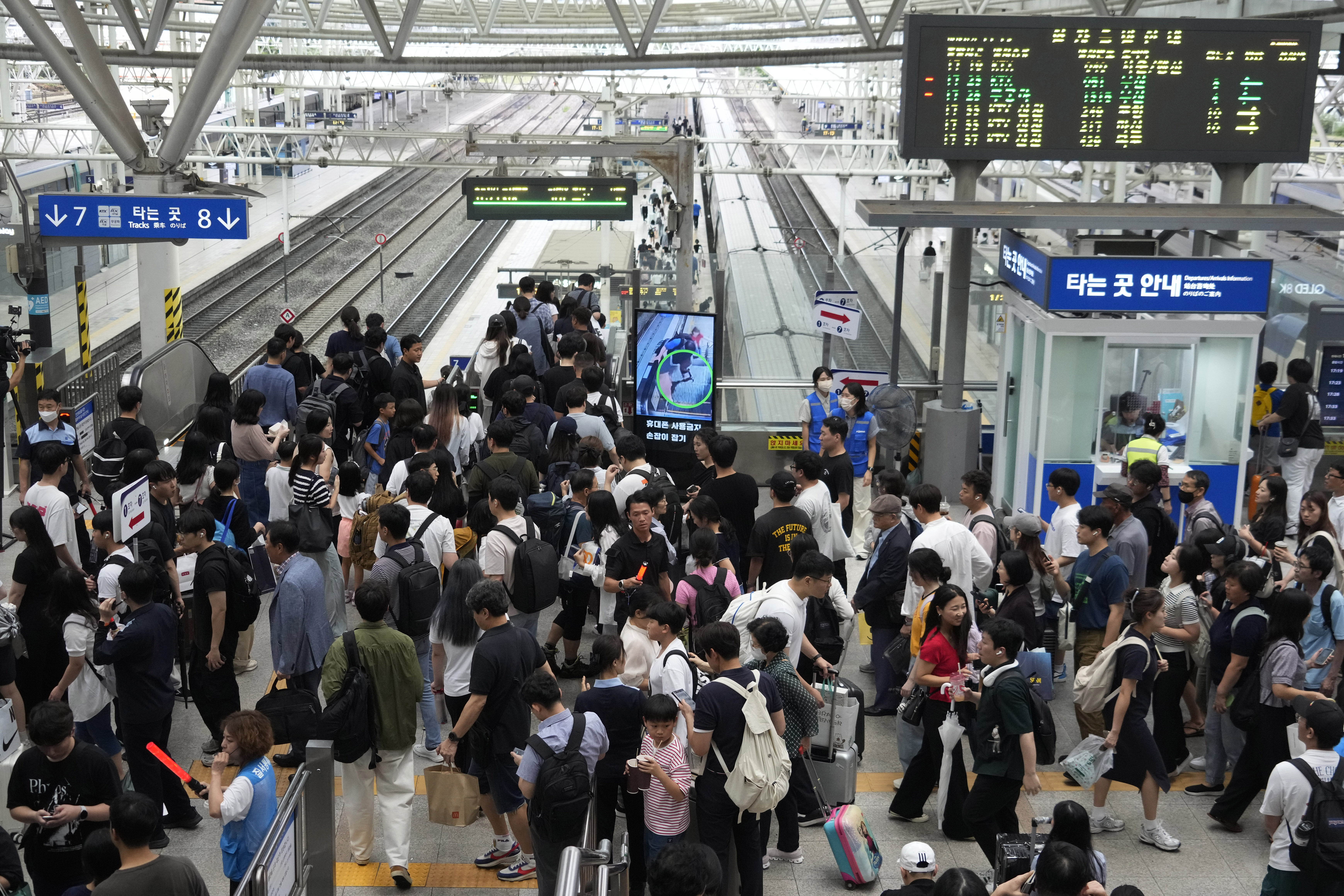 People move to board a train ahead of the upcoming "Chuseok" holiday, the Korean version of Thanksgiving Day, which falls on Sept. 17, at the Seoul Railway Station in Seoul, South Korea, Friday, Sept. 13, 2024. (AP Photo/Ahn Young-joon)