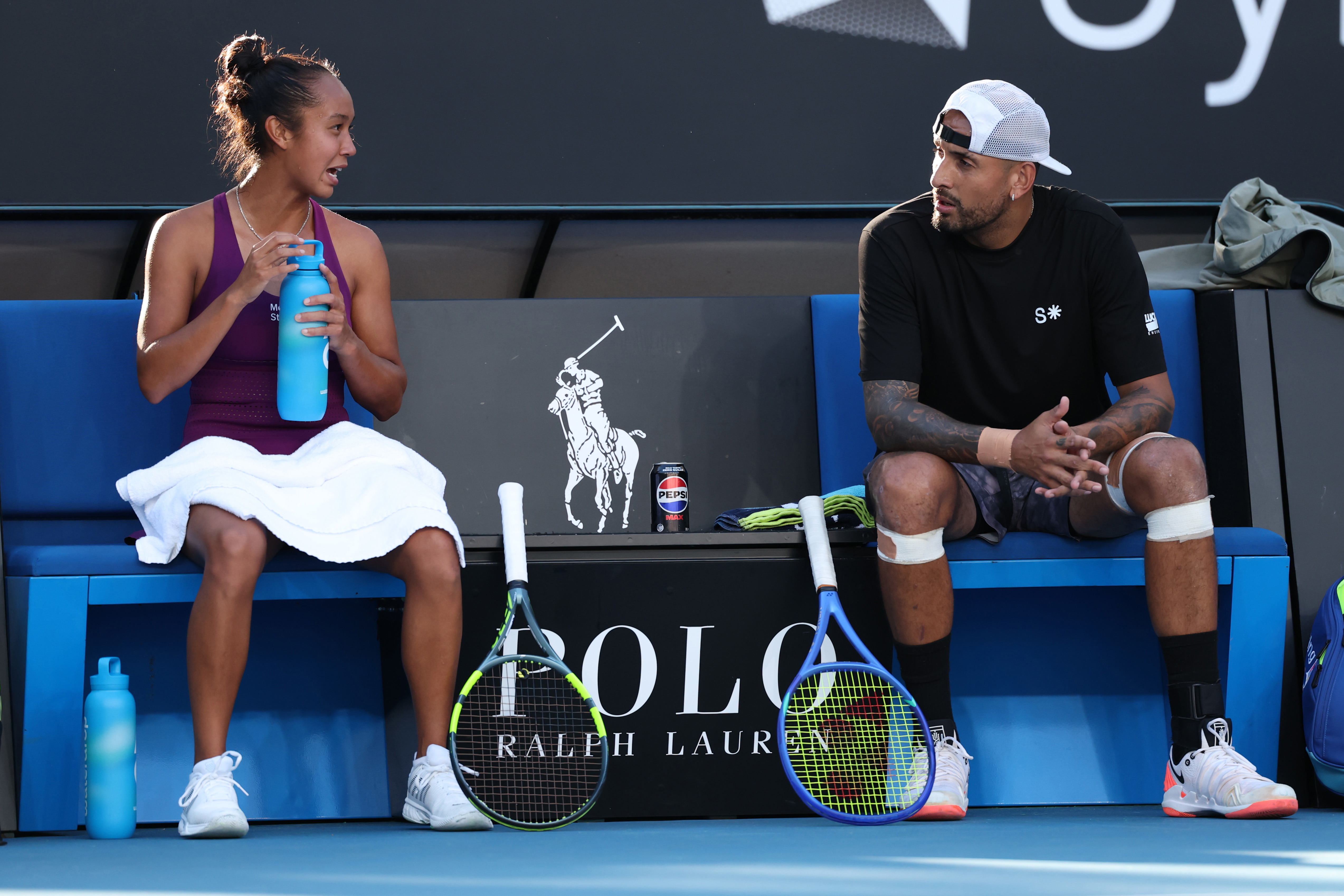 Nick Kyrgios of Australia talks with Leylah Fernandez of Canada competing at the AO mixed doubles.