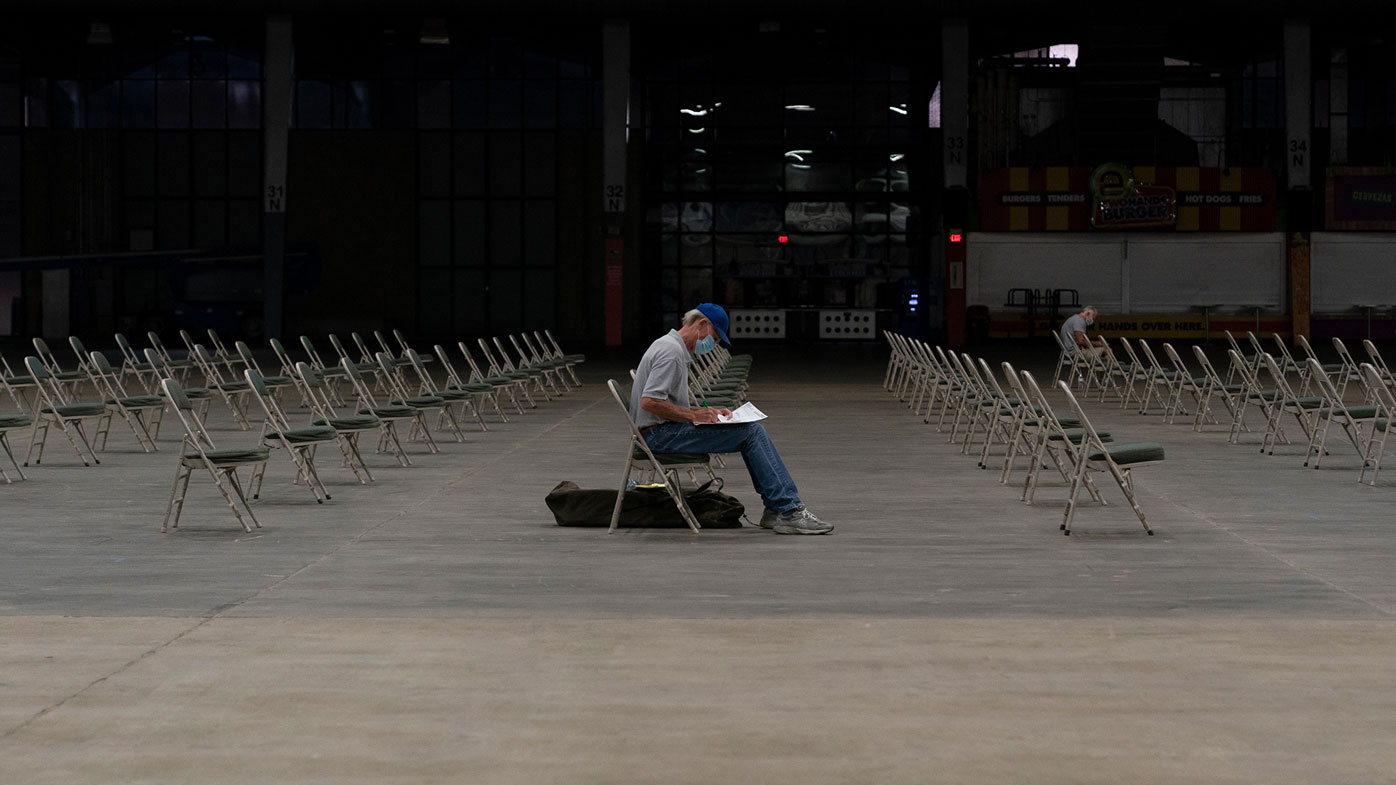 A man fills out paperwork while waiting for his number to be called at an unemployment event in Tulsa, Oklahoma on July 15, 2020