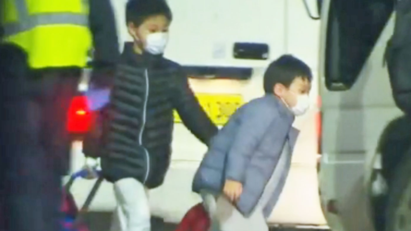 Two children board a Qantas flight in Wuhan, headed for Darwin.